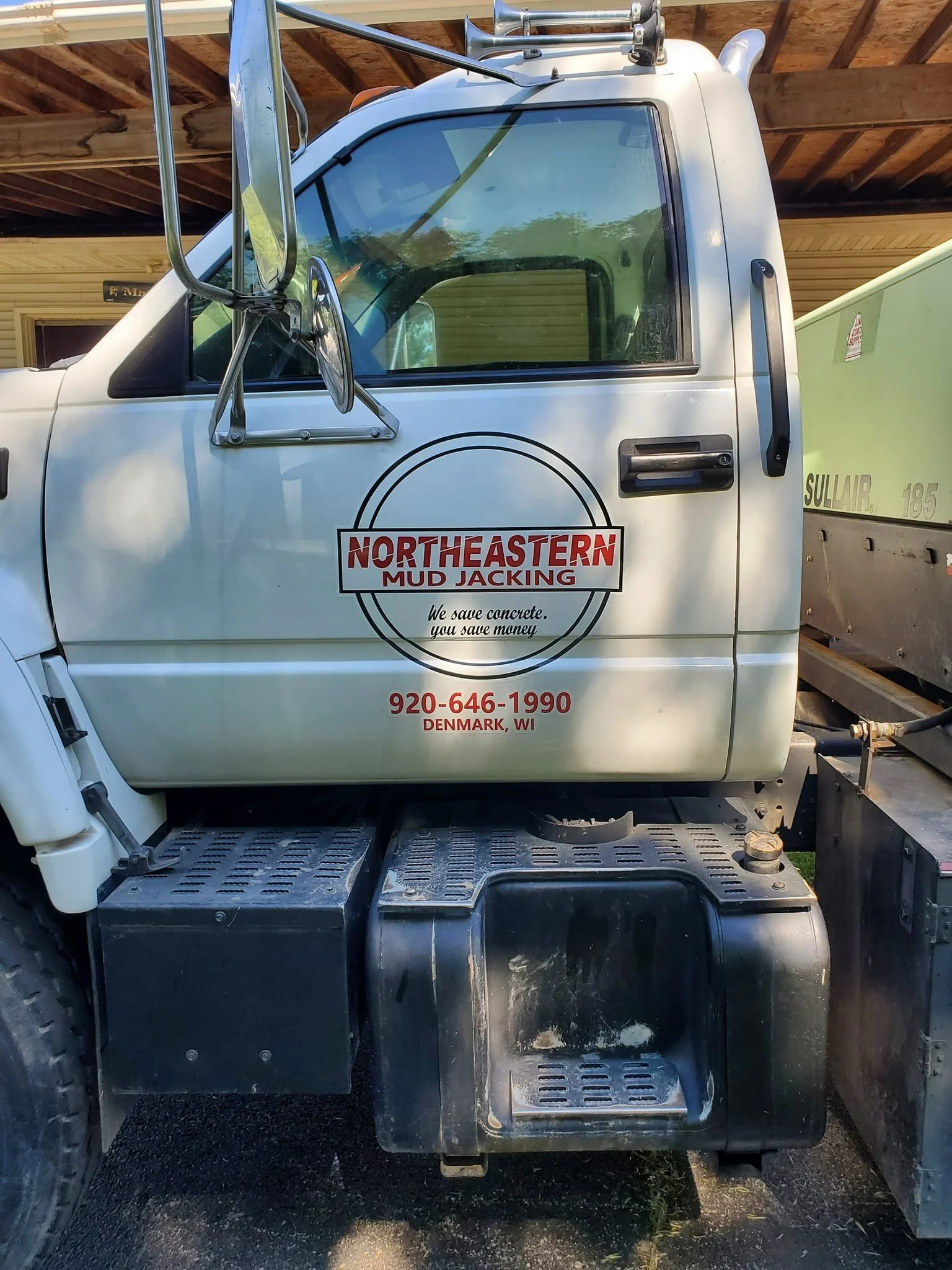 Truck with logo on door reading 'Northeastern Mud Jacking,' phone number 920-646-1990, located in Denmark, WI.