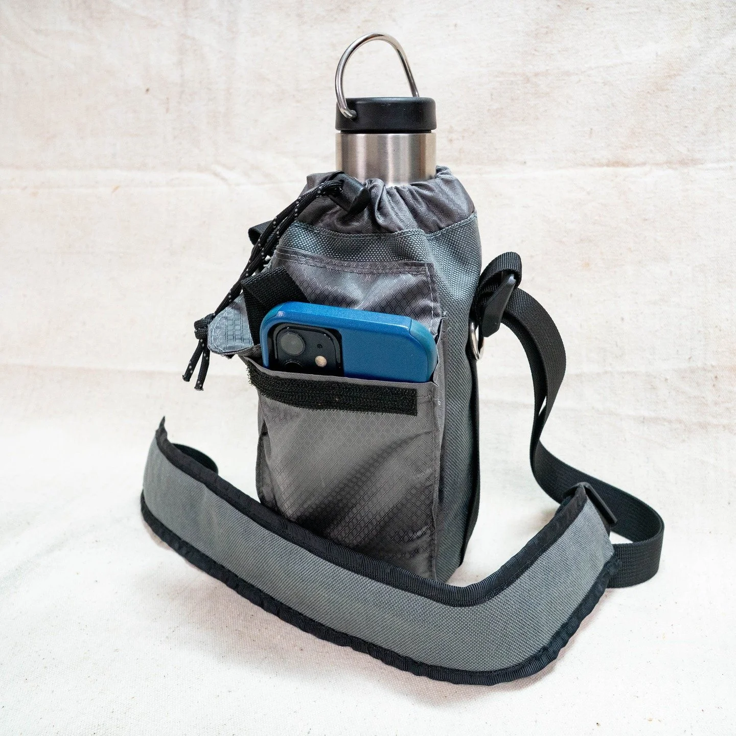 Got a special order water bottle sling stitched up and ready to ship out. This is designed around a 1 L Nalgene but can fit bottles a little bigger too. Cinch top to keep your drinks in. One side has a hook and loop closure phone pocket with internal