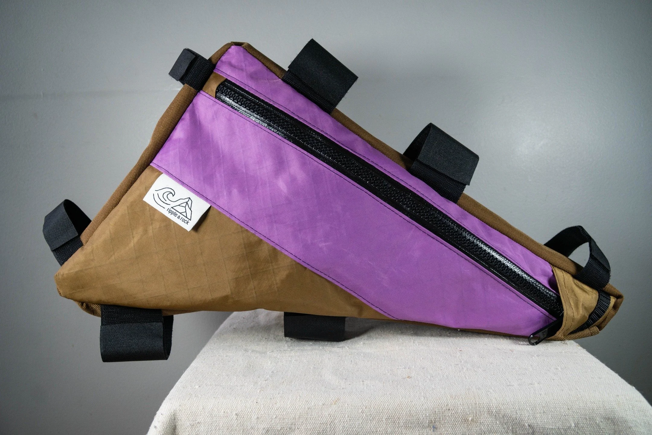 Chasing themes here this week: another frame bag and another fun color combo. This one has a taper; narrower in the back and wider up front to balance leg clearance and capacity. Full depth pocket on the non-drive side has organization pockets for a 