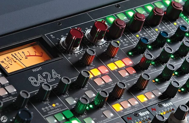 Audio mixing console with various colorful knobs and sliders.