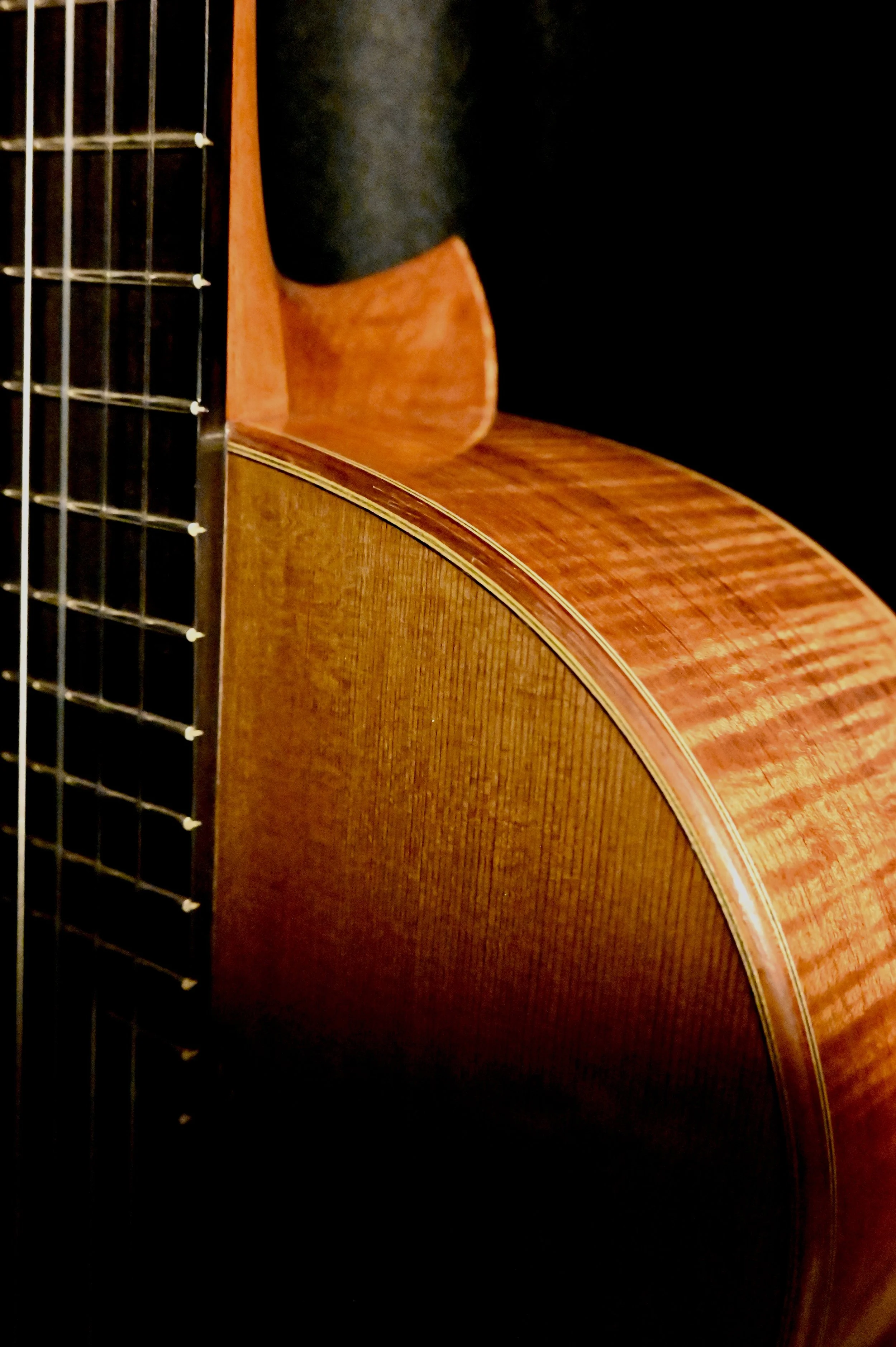 Close-up of a wooden acoustic guitar showing the body, neck, and strings.