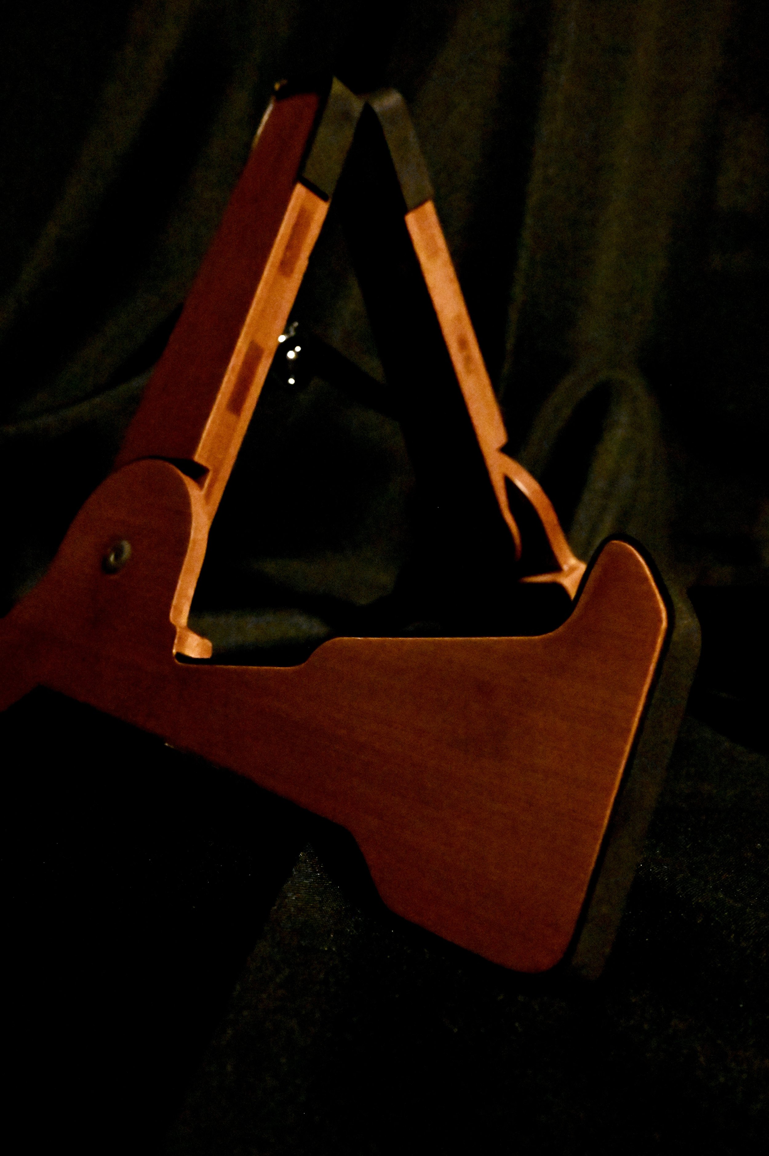 A wooden picture frame resting on a black fabric surface.