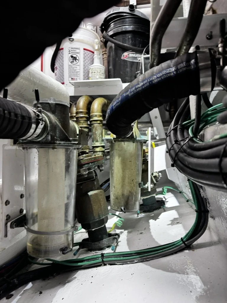 Close-up of mechanical equipment, including filters, pipes, hoses, and wires, inside an industrial machine or system.