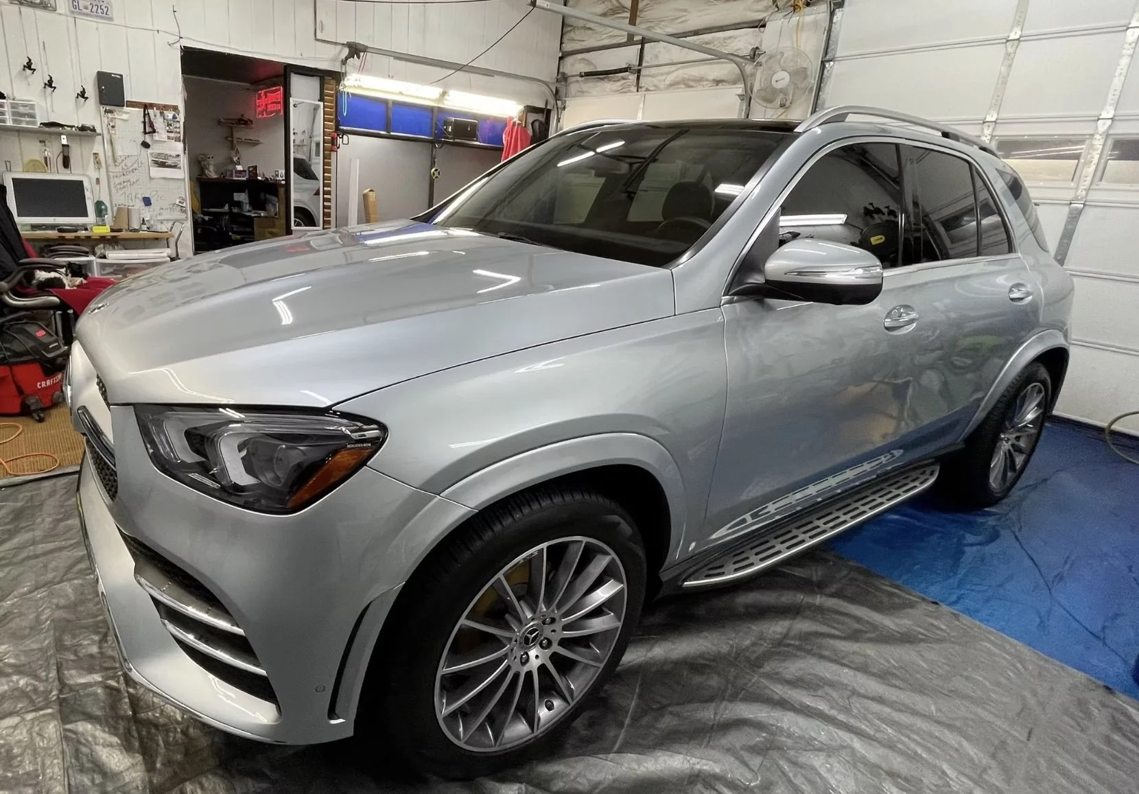 A silver Mercedes-Benz SUV parked inside a garage.