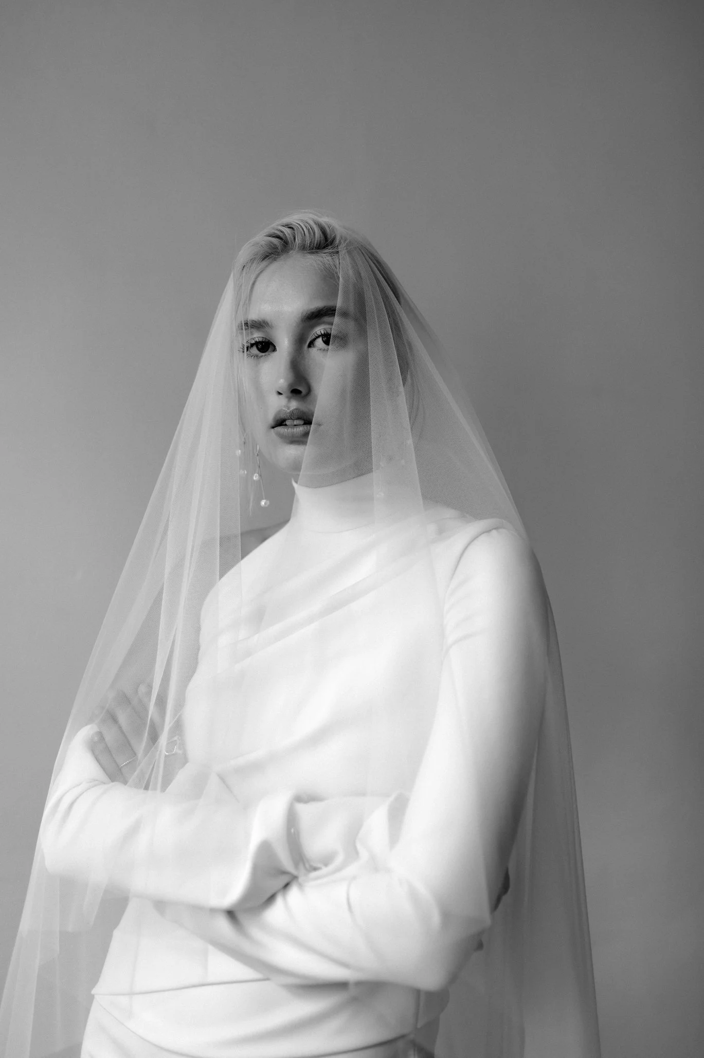 Brie with white dress and veil wears cascading gold and pearl earring