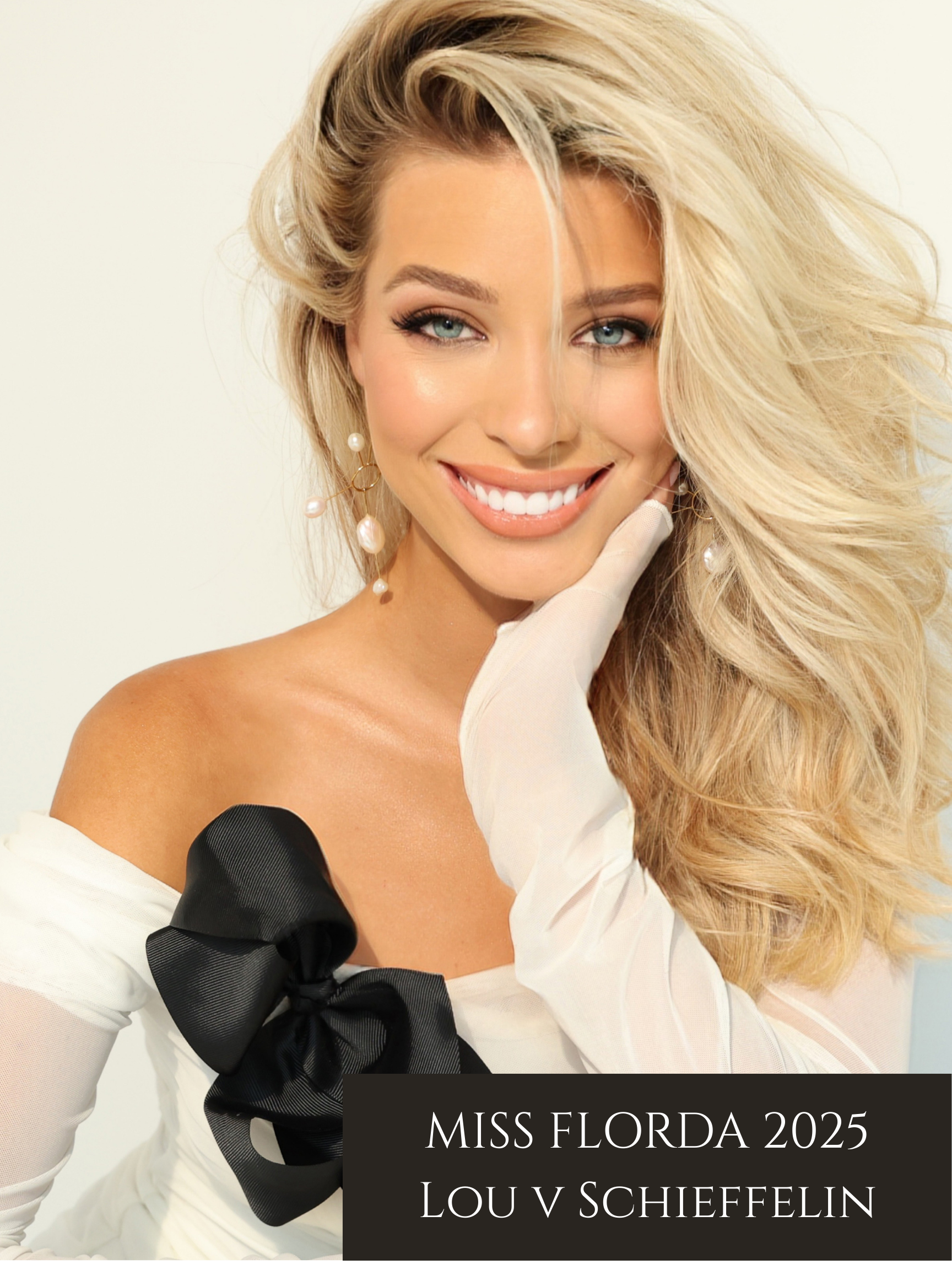 Miss Florida 2025 Lou V Schieffelin smiling with blonde hair and blue eyes, wearing white off-shoulder dress with a large black bow on her sleeve, and pearl earrings.
