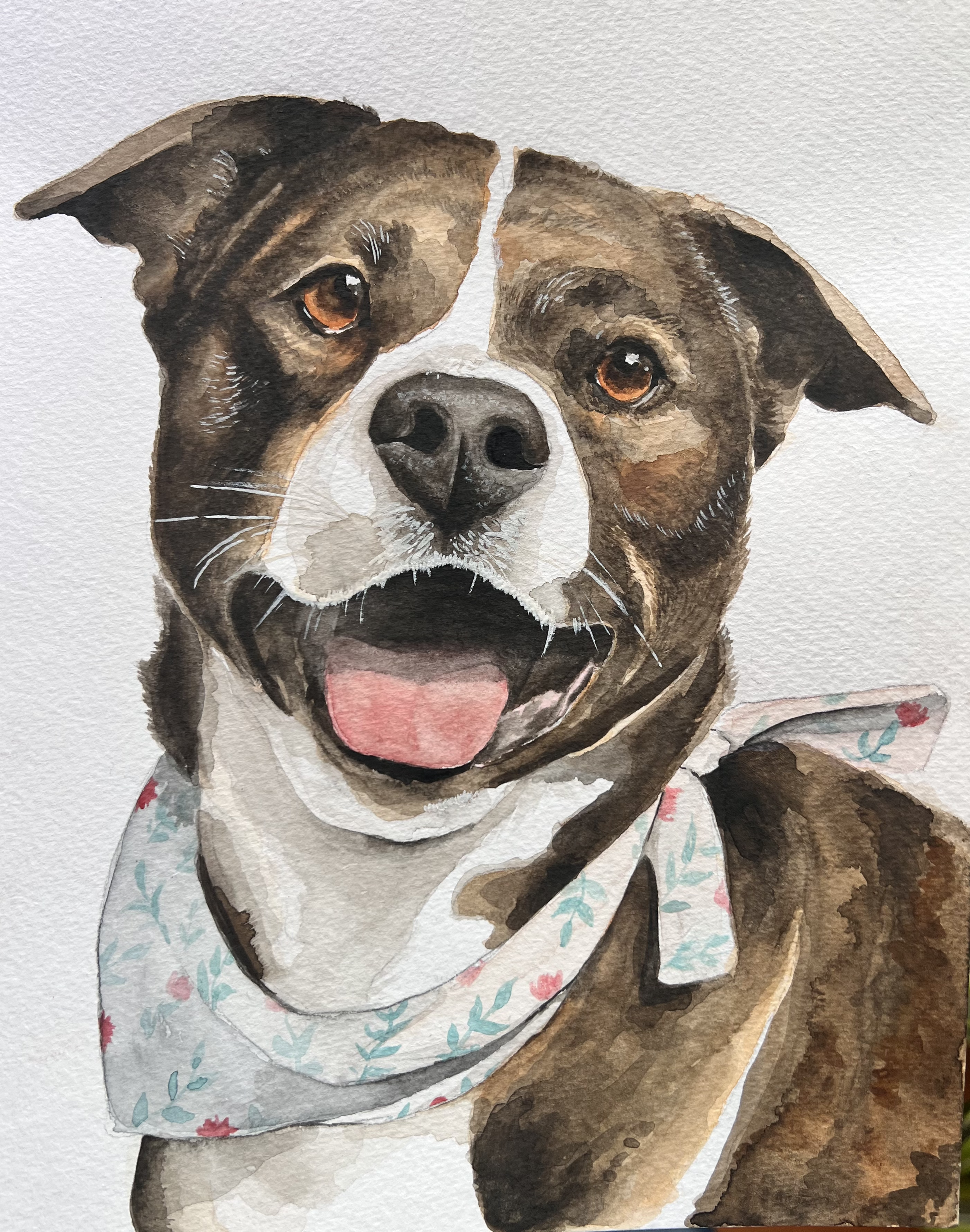 Watercolor painting of a happy dog with a floral bandana around its neck, showing its tongue and brown eyes.