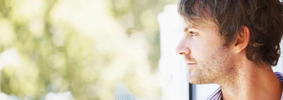 A man looking out the window in deep contemplation.