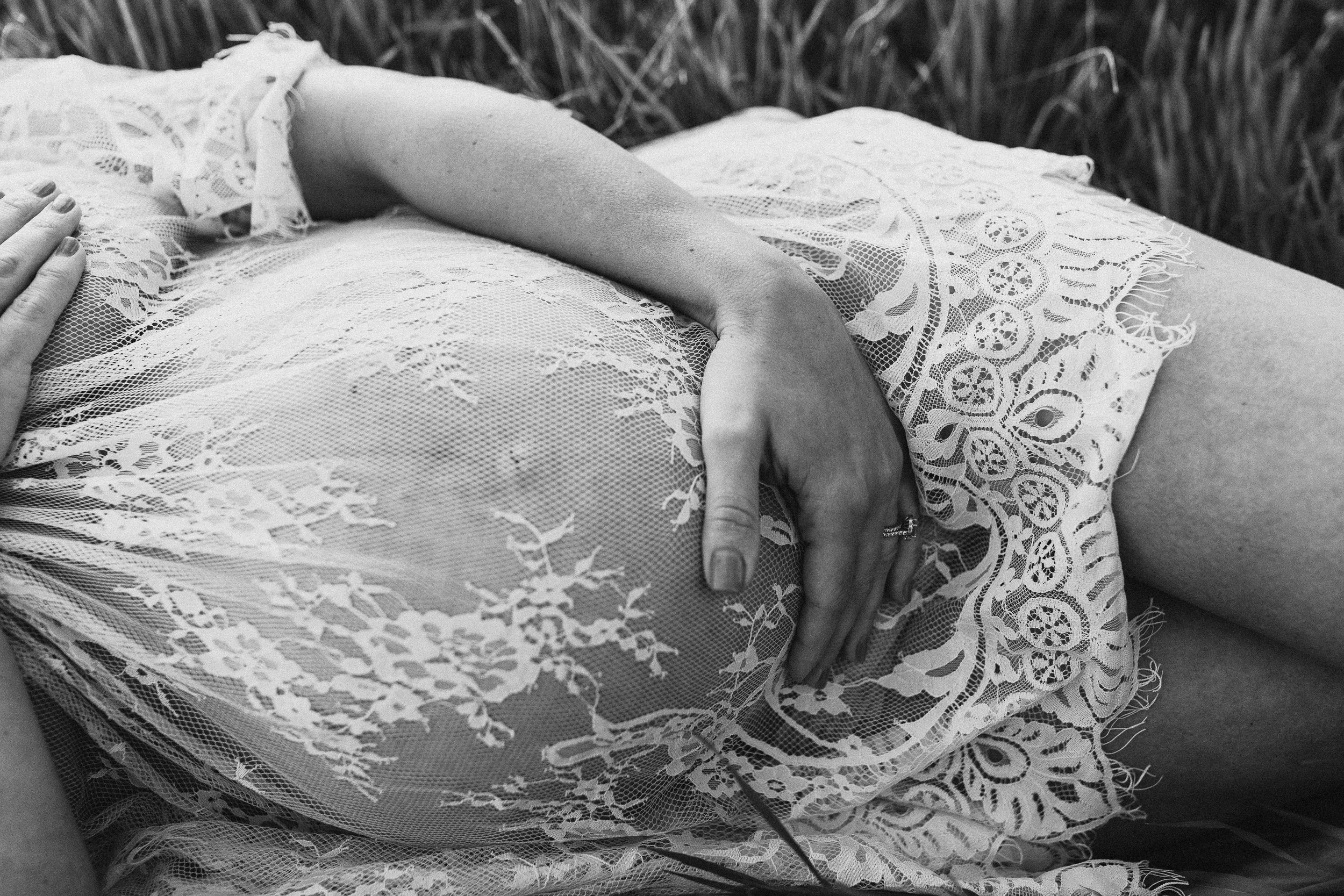 pregnant woman in see through lace chemise holding pregnant belly