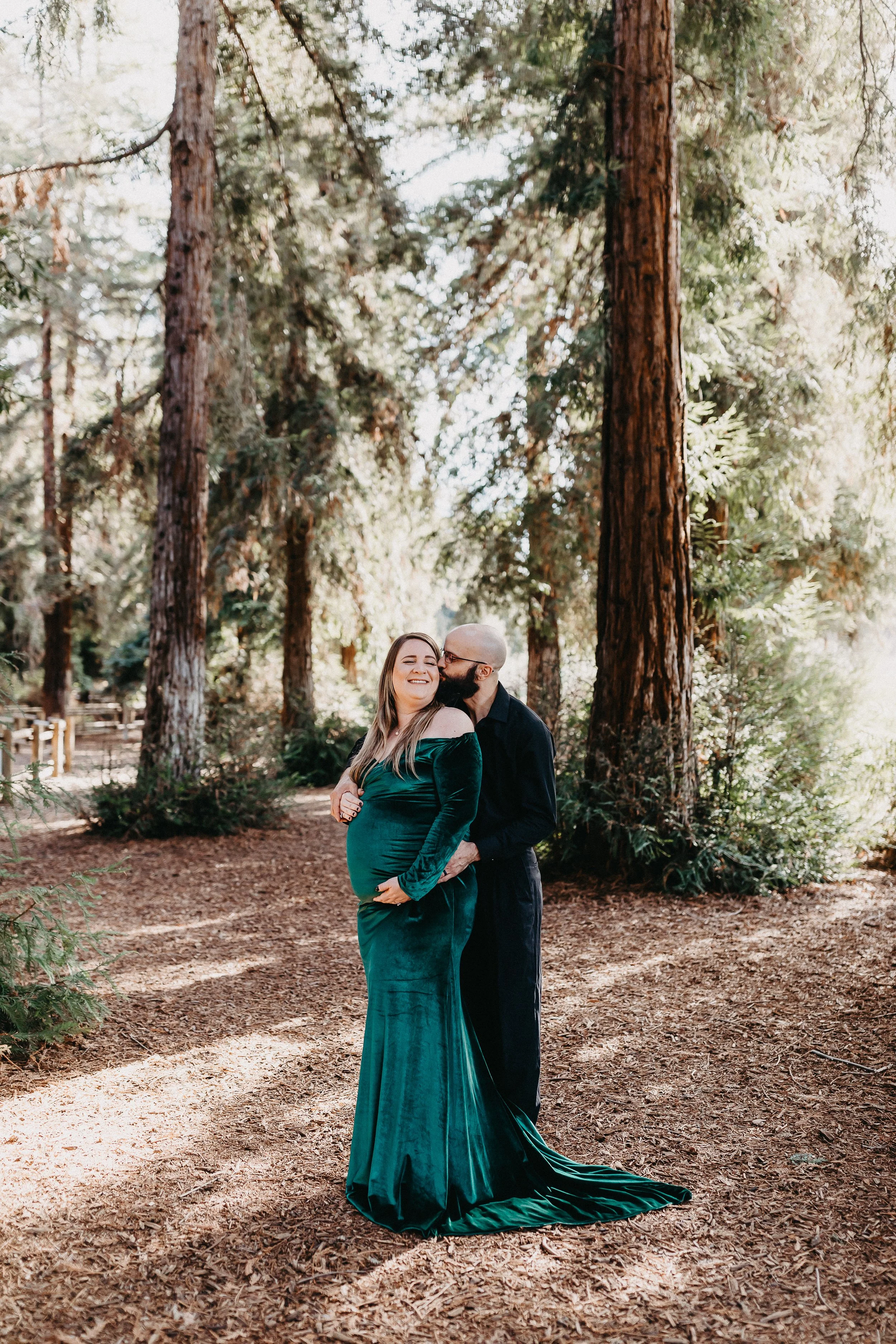 a woman and man amongst the Redwood Trees during their maternity session.