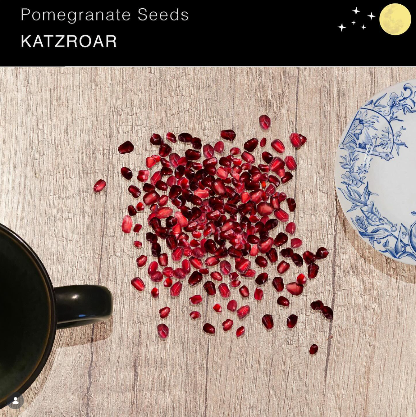 A tribute graphic to "Pomegranate Seeds" by KATZROAR. On the left is a black mug. In the  center is a bundle of pomegranate seeds. To the right is a white china plate with blue designs.