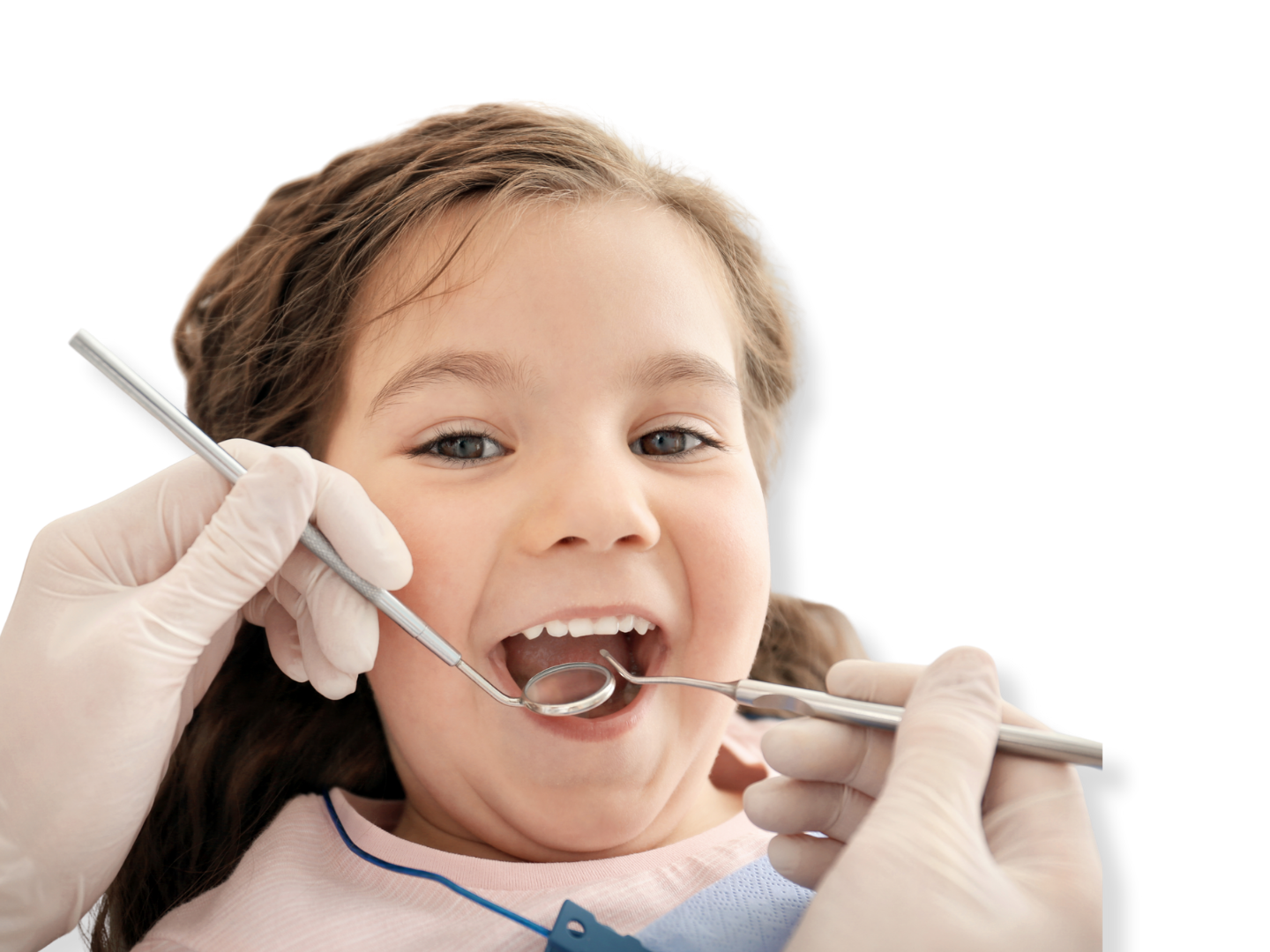 A young girl at the dentist's office, smiling with her mouth open while a dentist examines her teeth with dental tools.