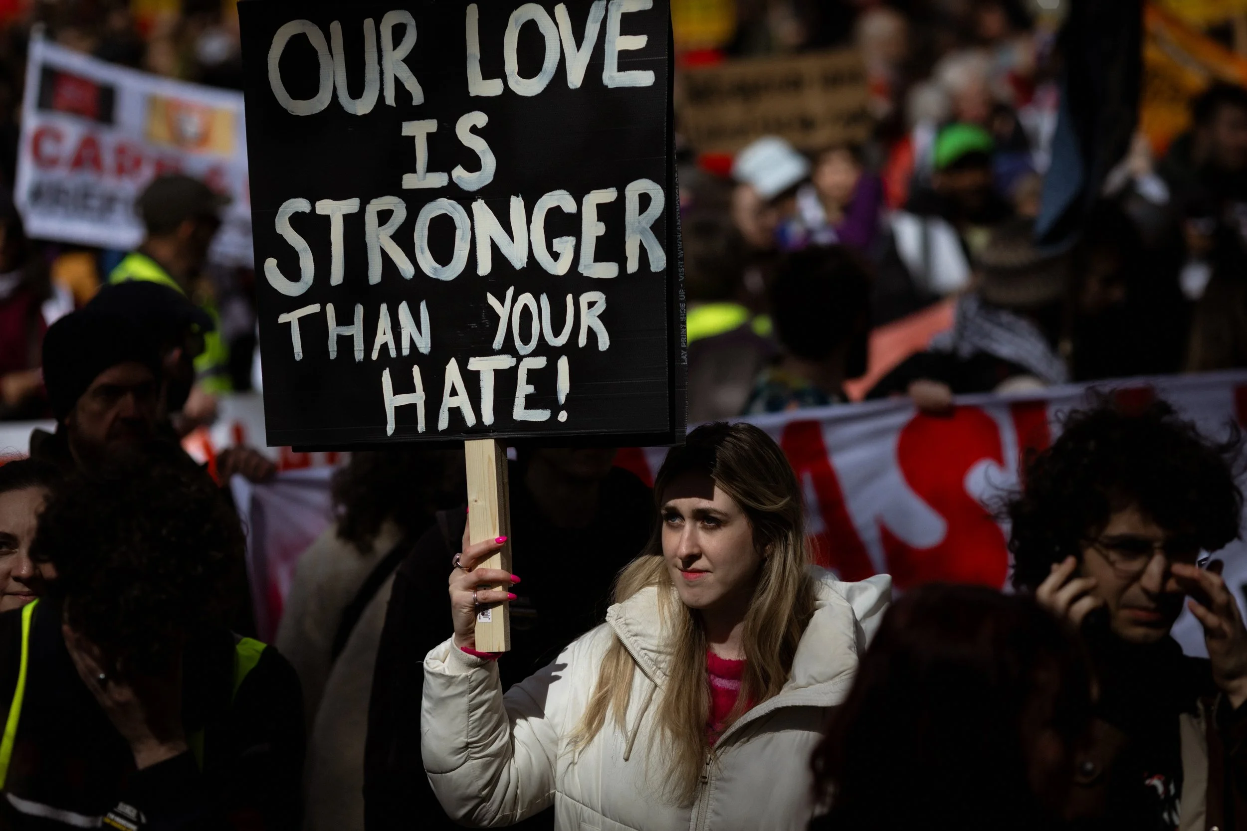 A protester carries a placard through the crowd before the start of the march.