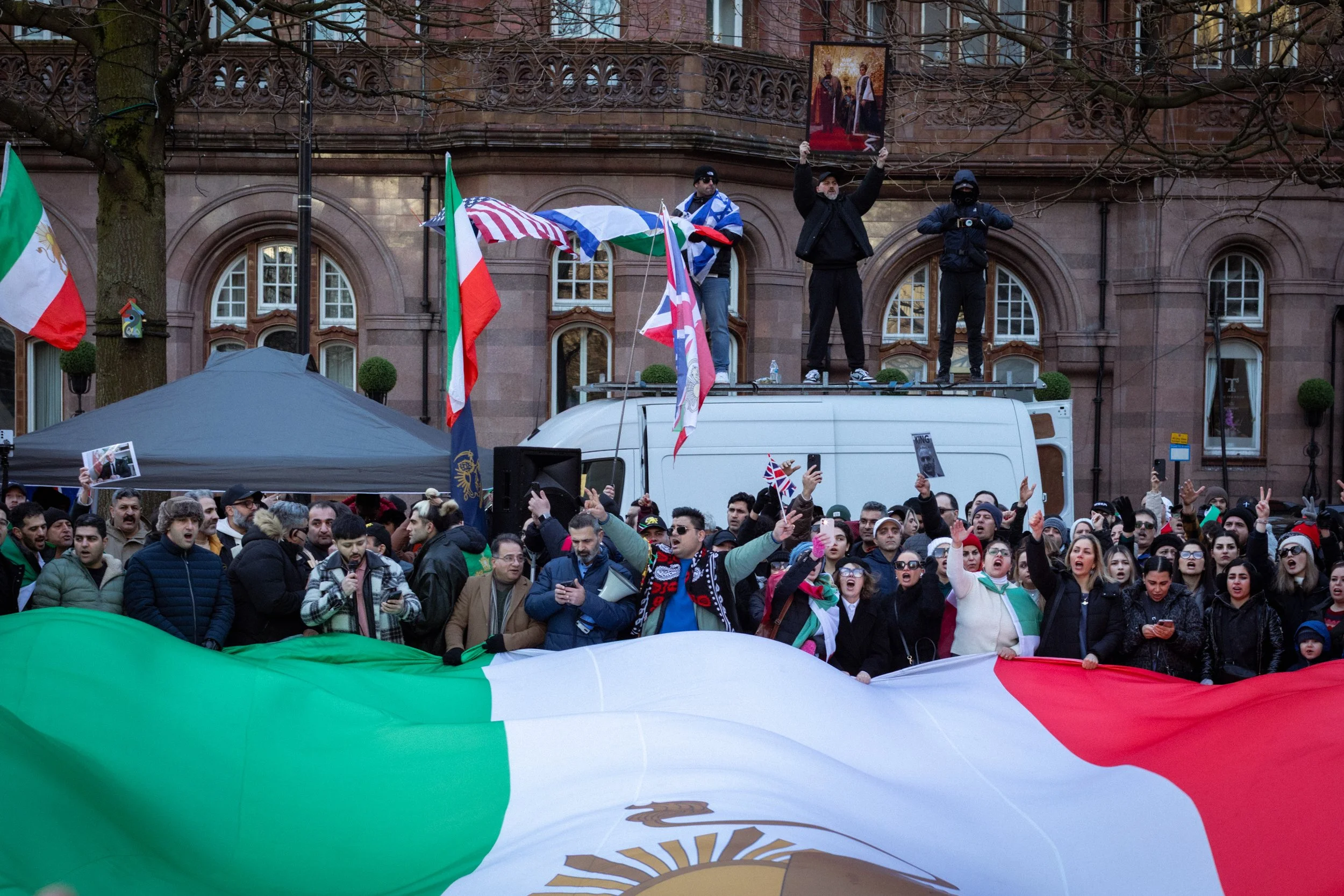 Iranian supporters gather around a large Iranian flag in St Peter's Square.