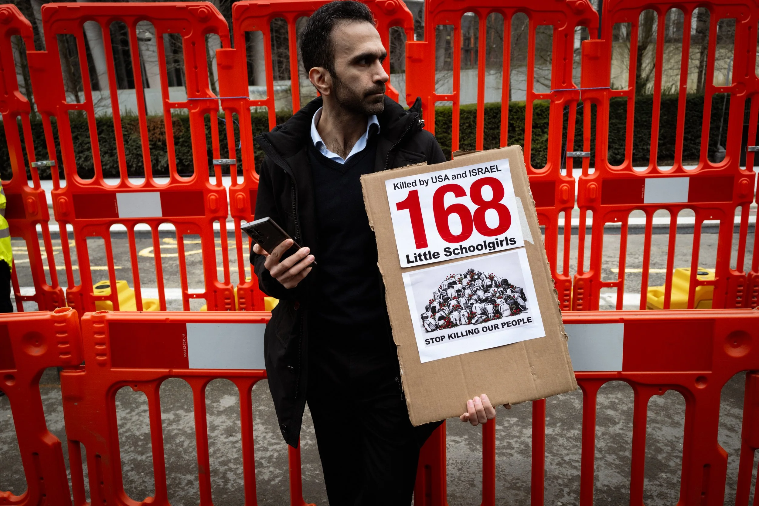 A man with a placard stands outside the American Embassy after a protest about the bombing of Iran. 
