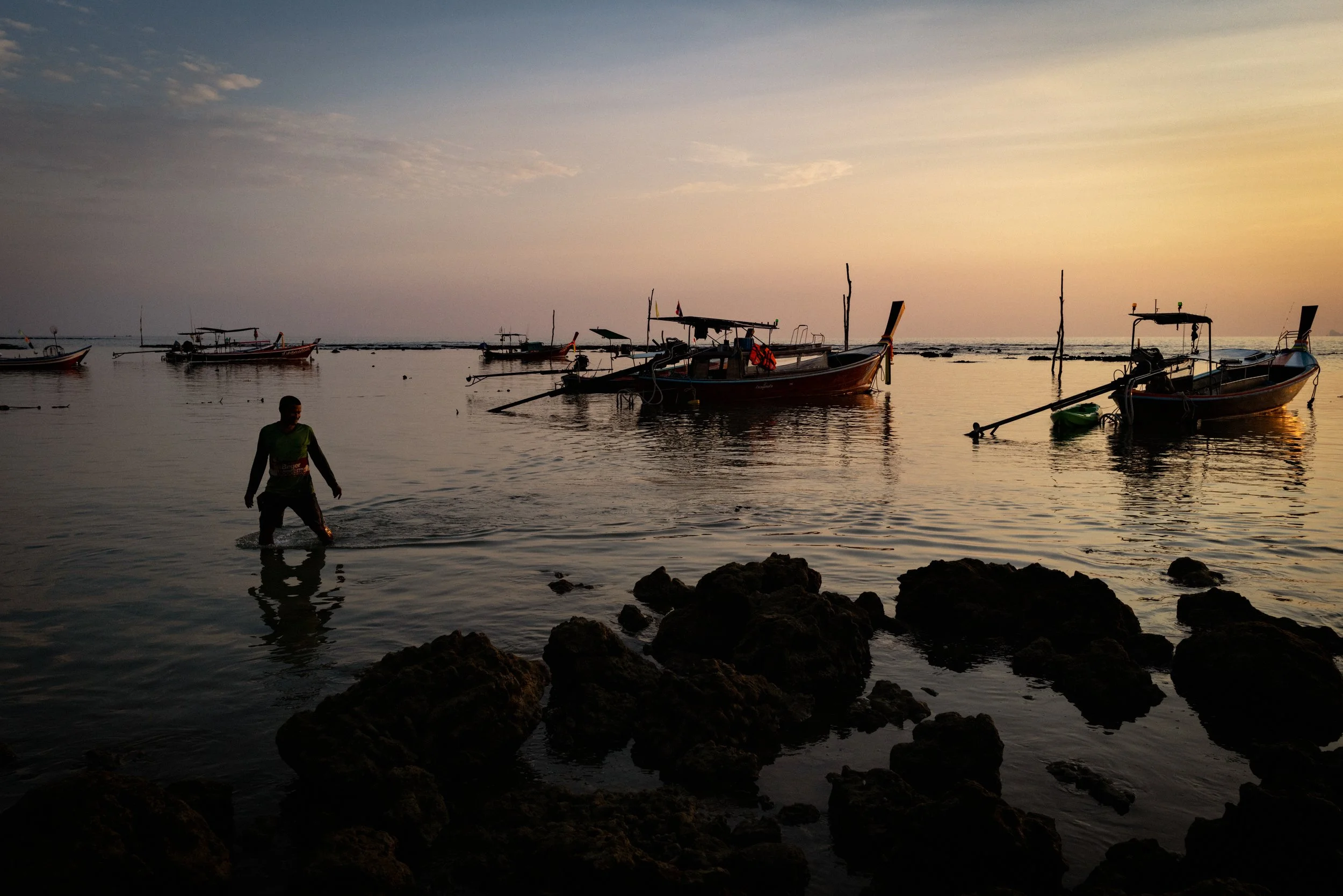 A fisherman returns to shore after fueling up a fishing boat before it heads out for the night. Ko Lanta, Thailand, 2025