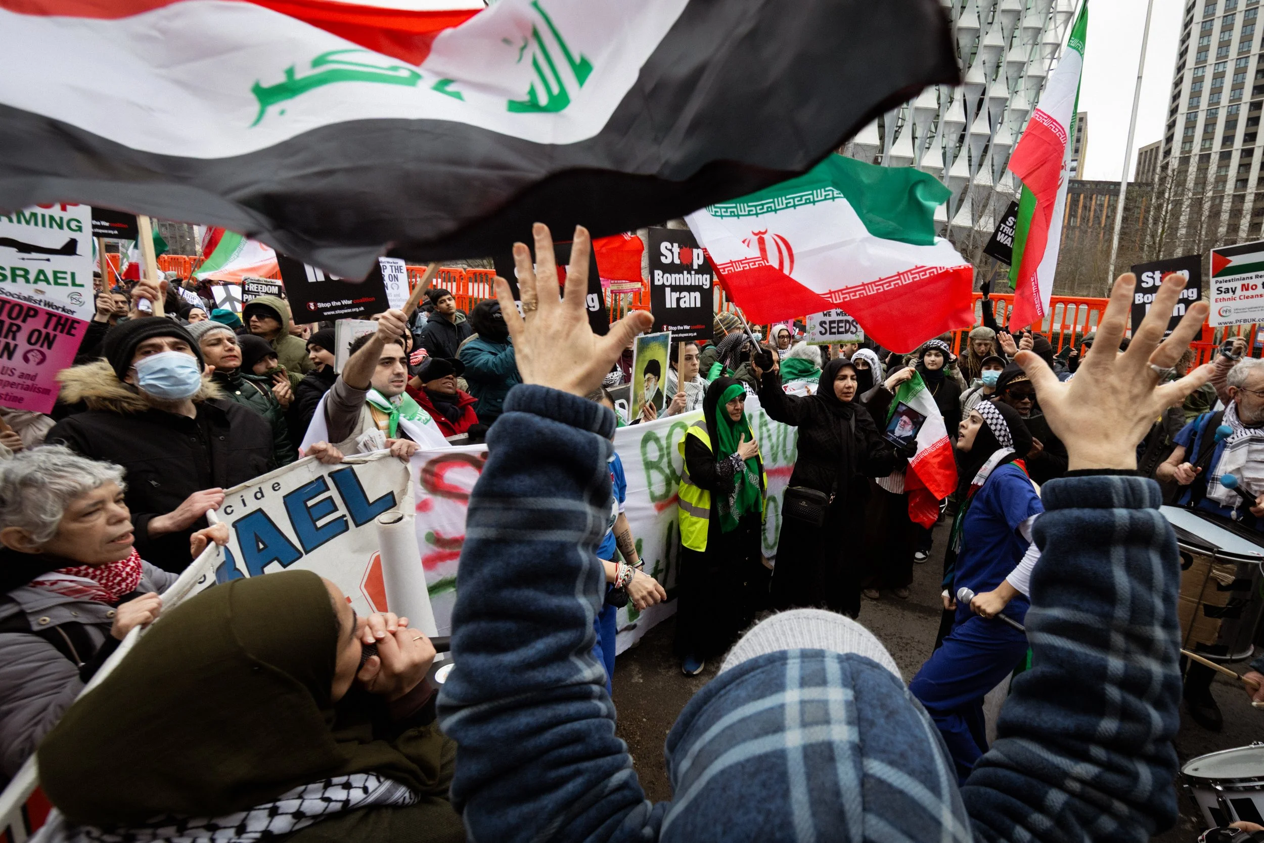 People gather outside the American Embassy and chant in protest against the bombing of Iran.