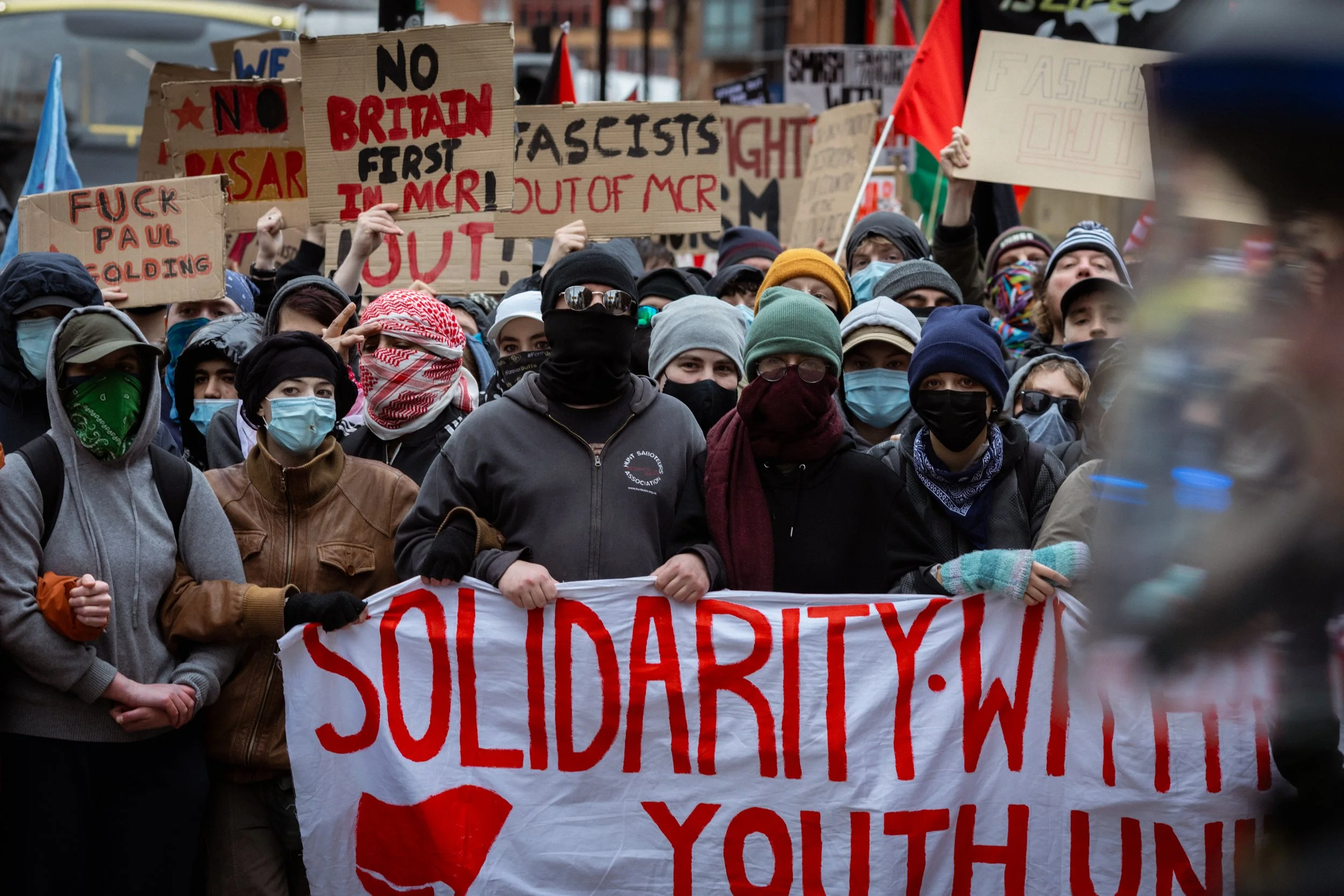People with banners and placards gather to counter-protest Britain First. 