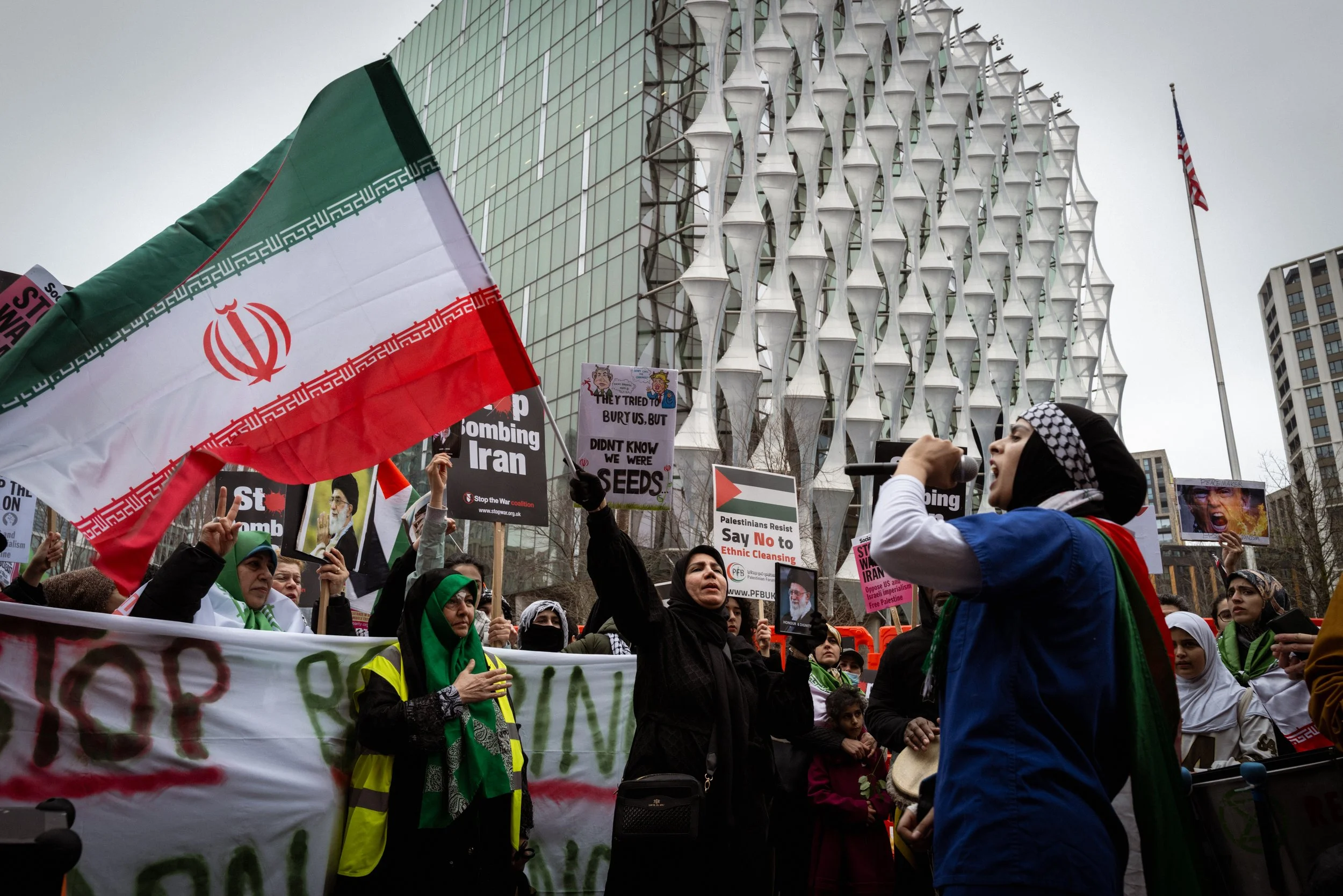 People gather outside the American Embassy and chant in protest against the bombing of Iran. 