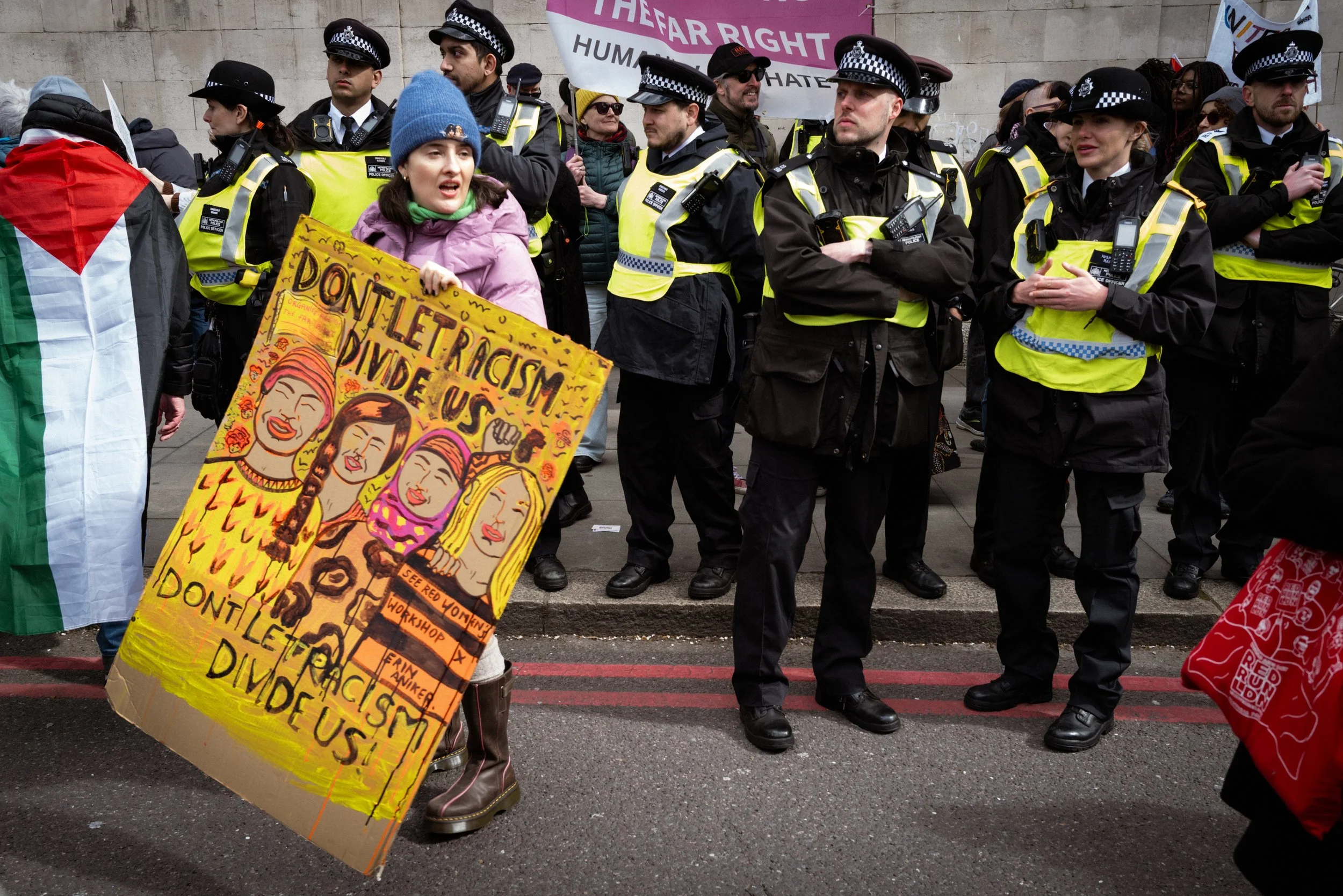 A protester carries a large placard past the police ahead of the march's start.