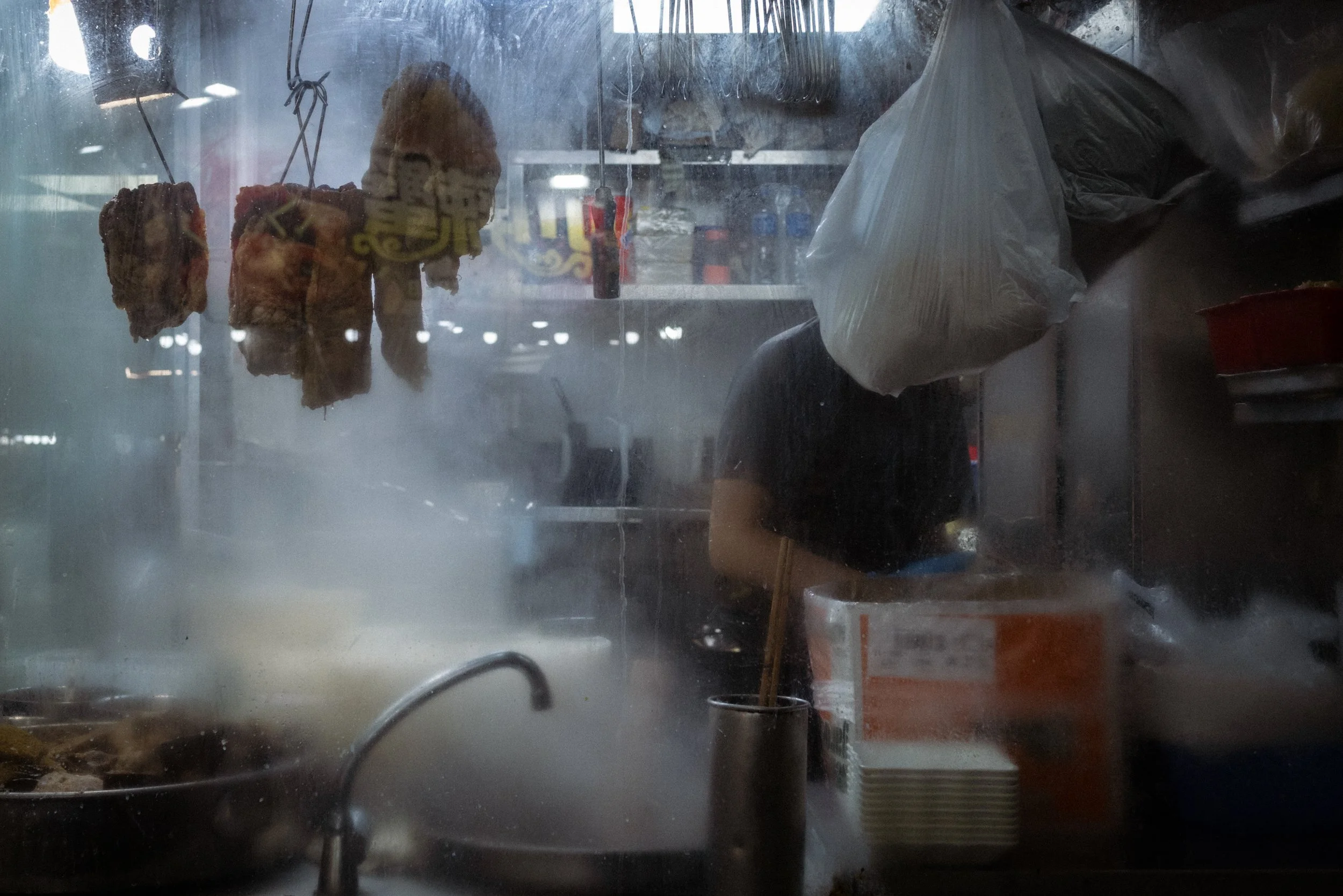 A chef prepares food in a small kitchen in downtown Kowloon. Hong Kong, China, 2025