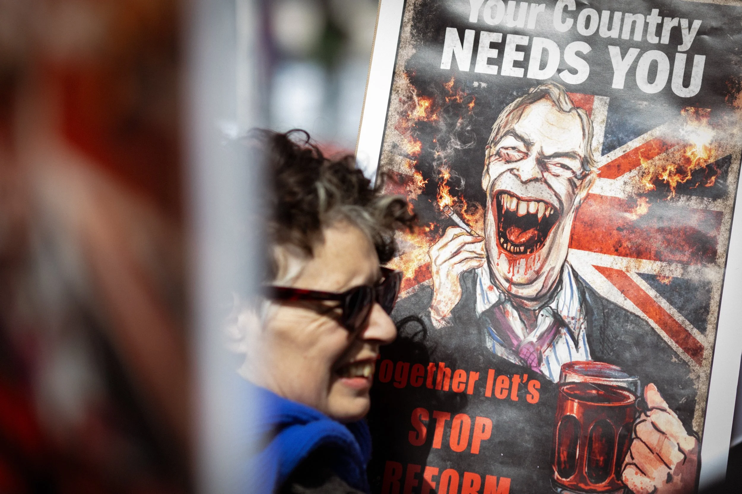 A protester holds a placard depicting Nigel Farage before the start of the march. 