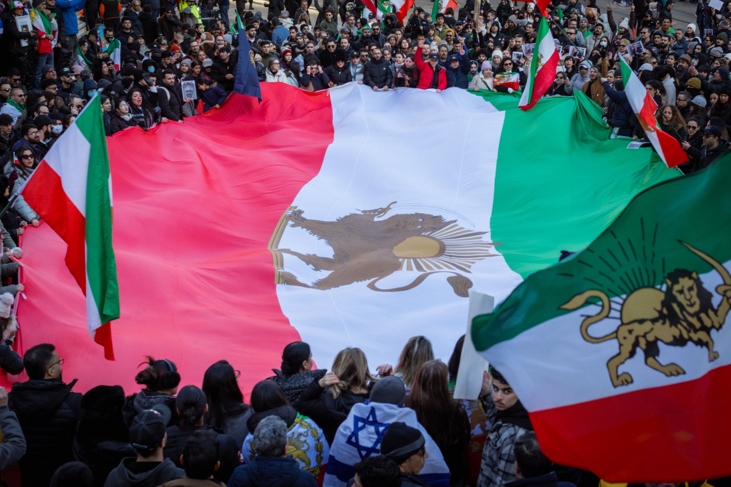 Iranian supporters gather around a large Iranian flag in St Peter's Square. 