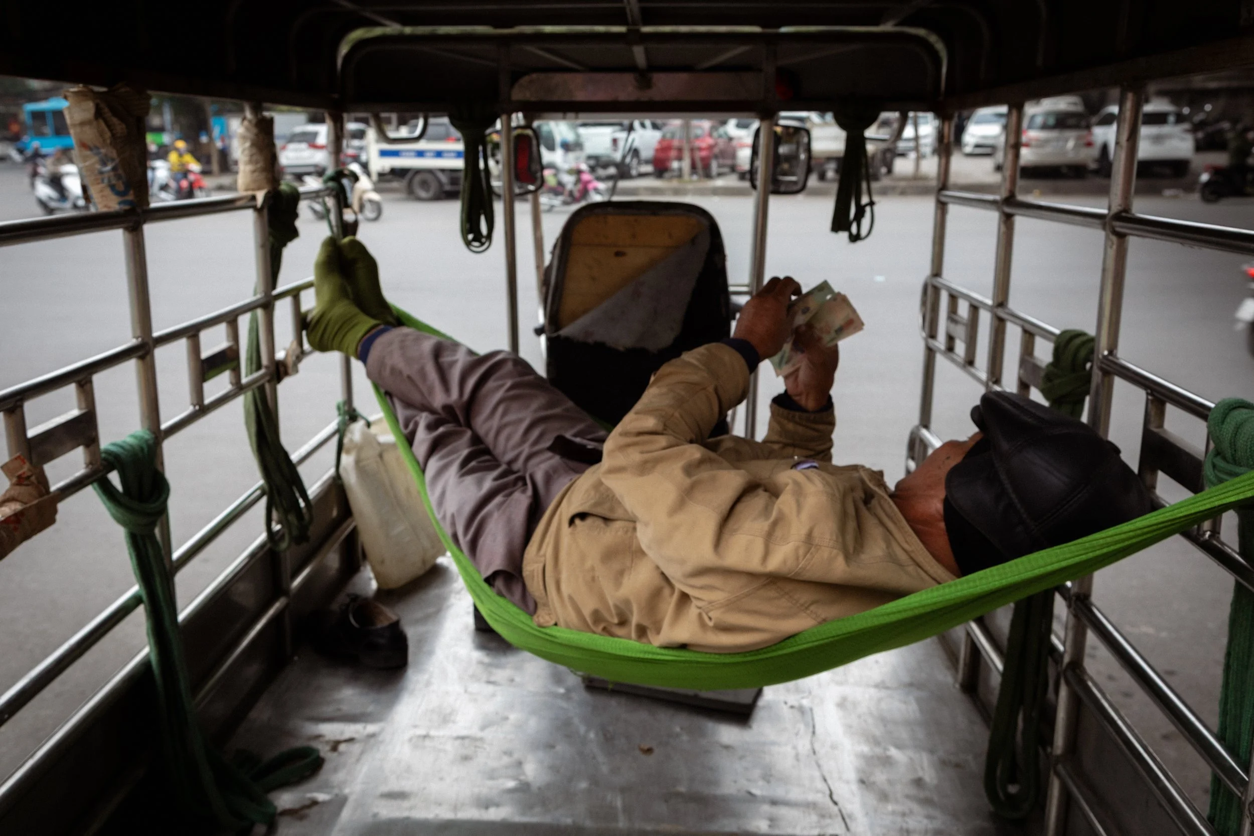 A taxi driver counts his cash. Hanoi, Vietnam, 2019