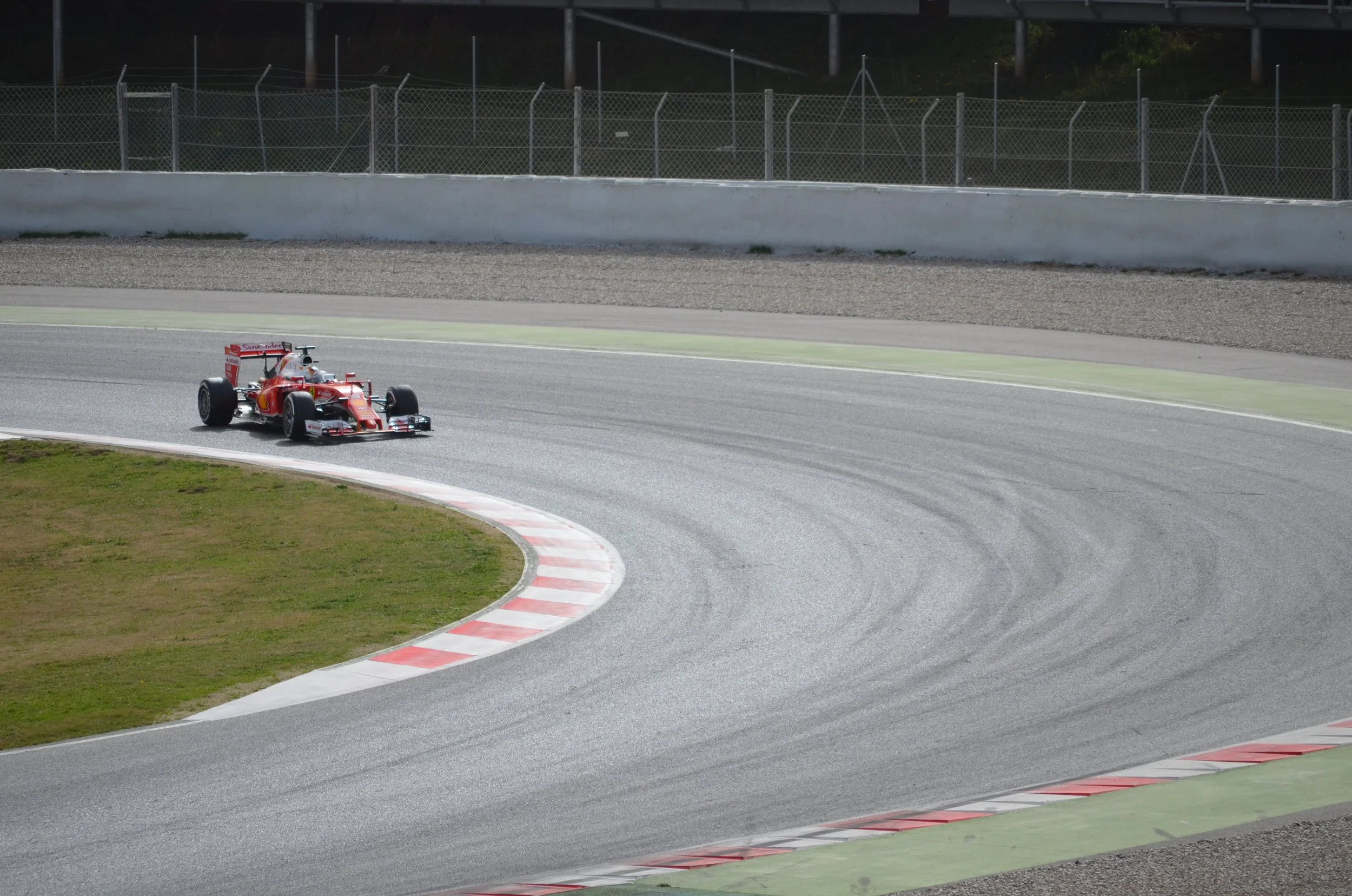 Un coche de carreras en una curva de la pista de un circuito de autos.