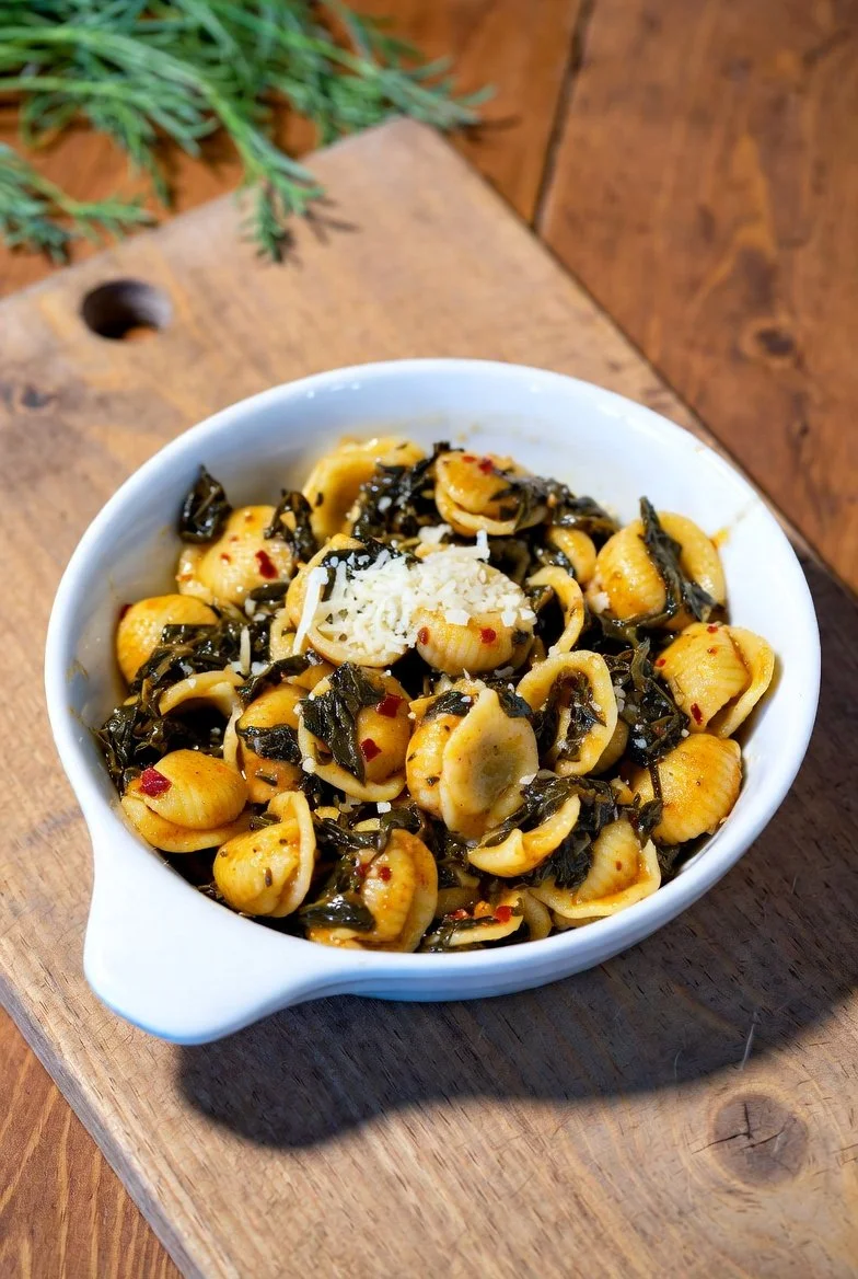 Traditional handmade Orecchiette pasta with turnip greens (cime di rapa), garlic, and chili—Puglia’s iconic national dish served in an authentic rustic setting.