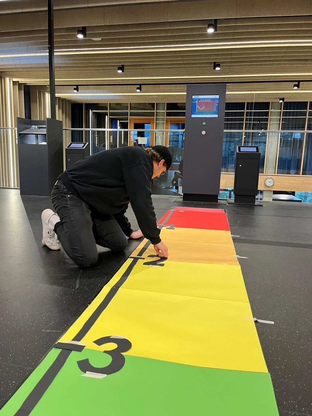 Eine Person, die einen usability Test vorbereitet indem sie Markierungen am Boden befestigt..