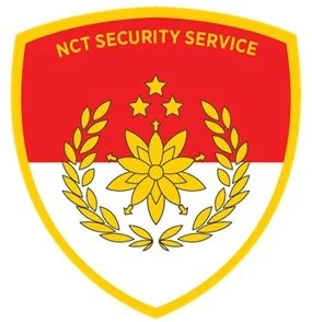 Shield-shaped emblem with red, white, and gold colors; features a yellow flower, four stars, laurel branches, and the text 'NCT Security Service' at the top.