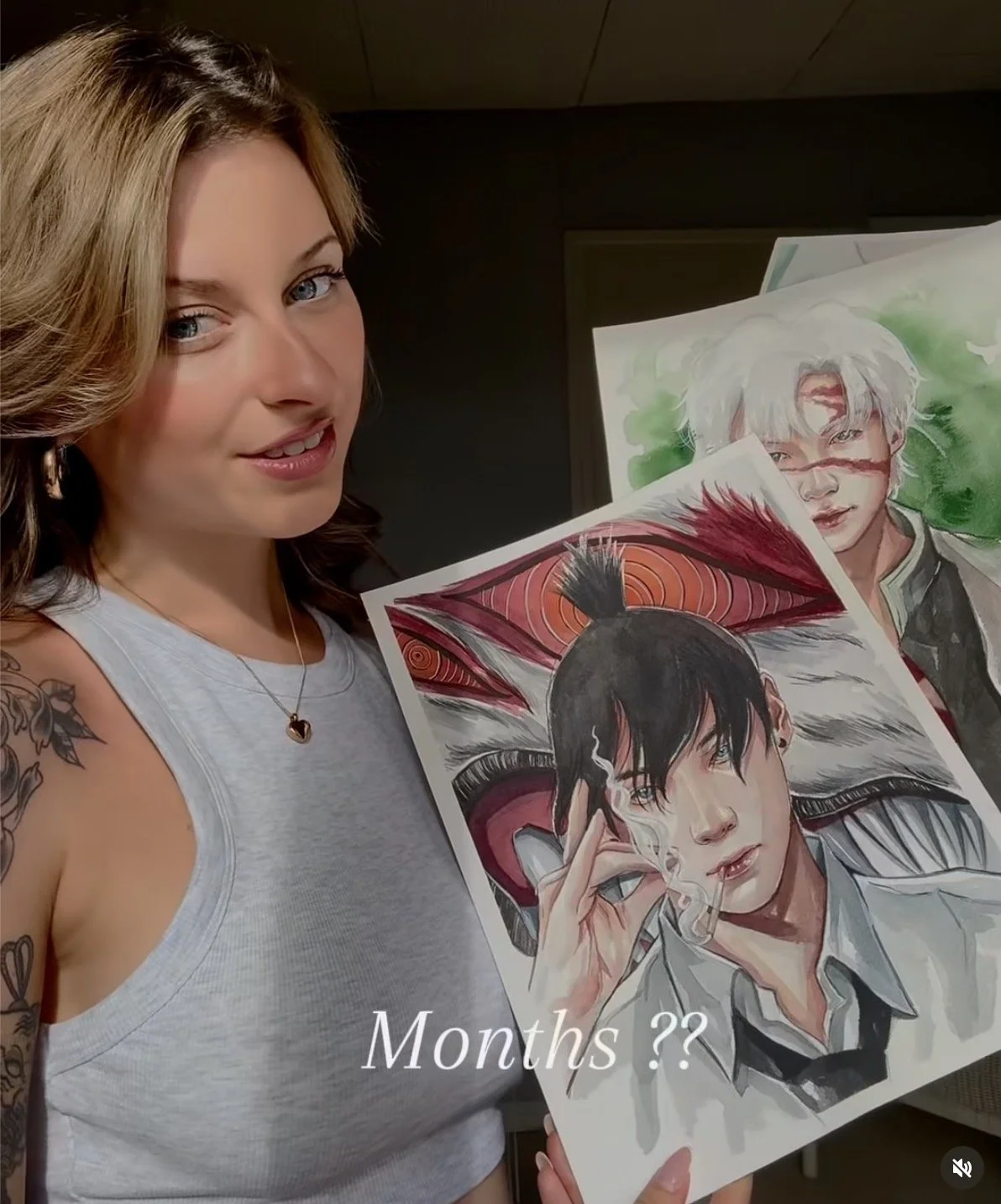 Une femme souriante tient une affiche de dessin d'un personnage de manga avec des cheveux noirs, un peigne, et une cigarette, avec le texte 'Months ??' écris en blanc. D'autres dessins sont visibles en arrière-plan.