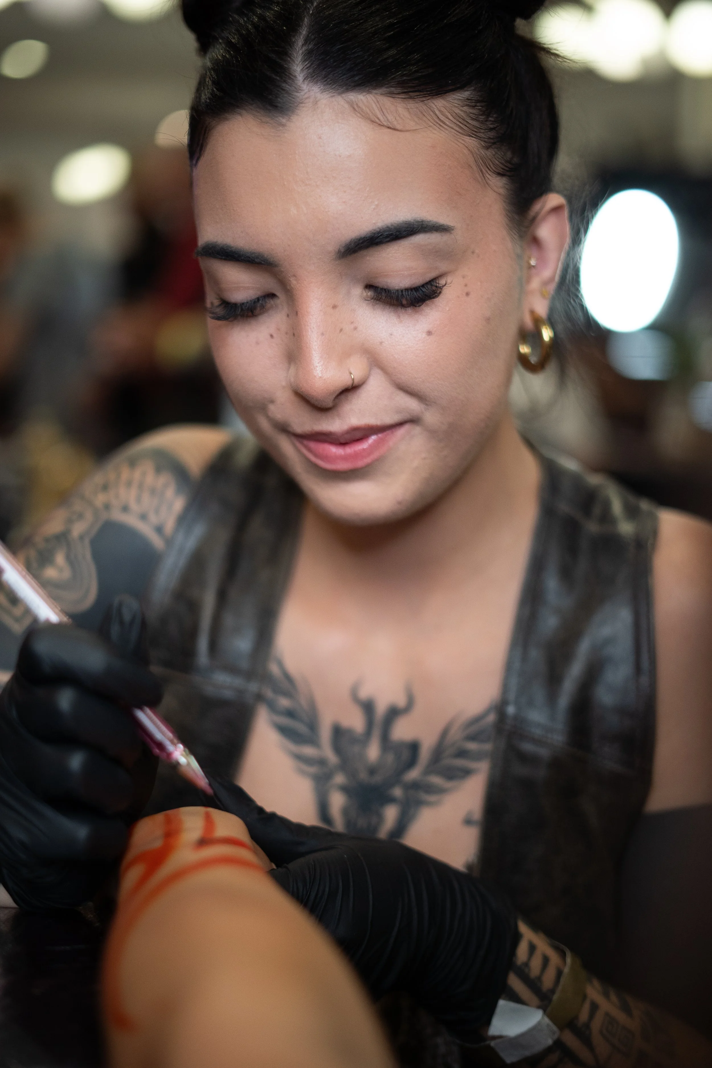 Daelhia en convetion qui tattoo la main d'une femme