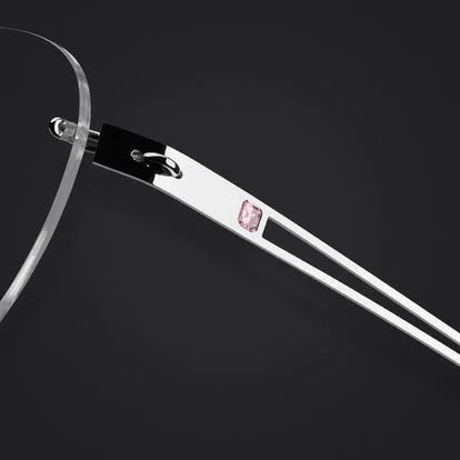 Close-up of a pair of silver-rimmed eyeglasses with one temple arm visible against a black background.