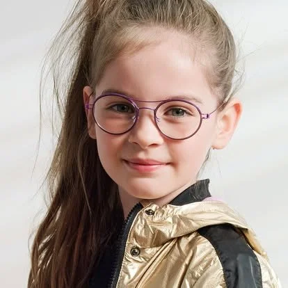 A young girl with glasses, long hair, and a gold and black jacket smiling at the camera.