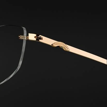 Close-up of a pair of eyeglasses with gold-colored temples and a black frame against a dark background.
