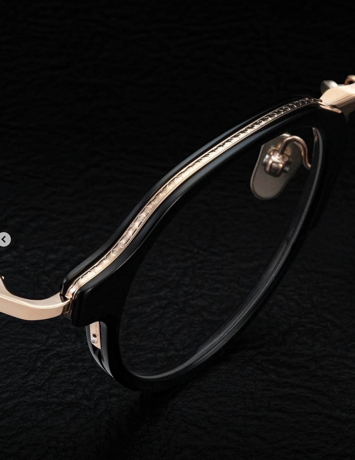 Close-up of a stylish wristwatch with a black strap and metallic accents on a dark textured background.