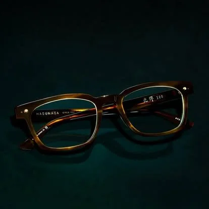 A pair of brown eyeglasses with clear lenses against a dark background.