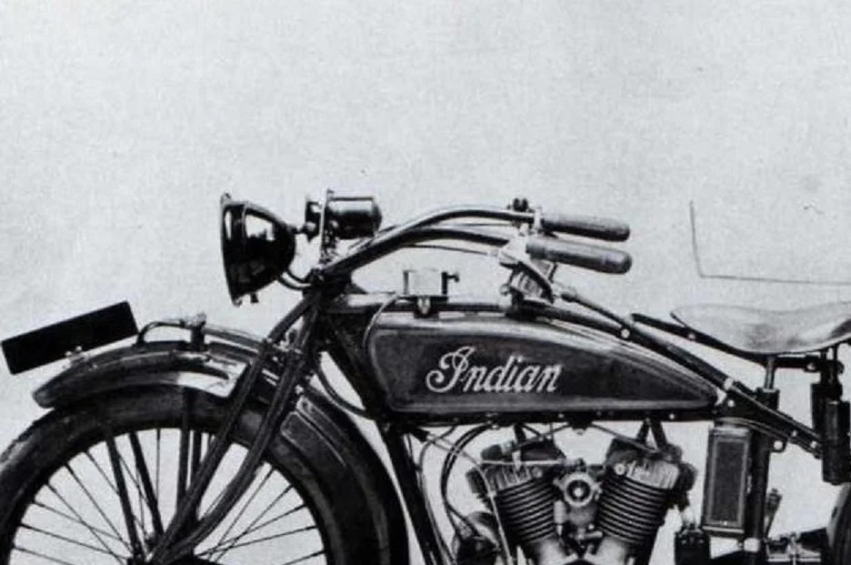 Black and white image of a vintage Indian motorcycle showing the front and middle parts.