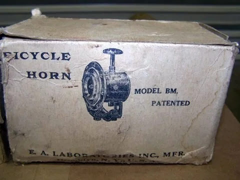Old box labeled 'Bicycle Horn Model BM Patented' with an illustration of a bicycle horn.