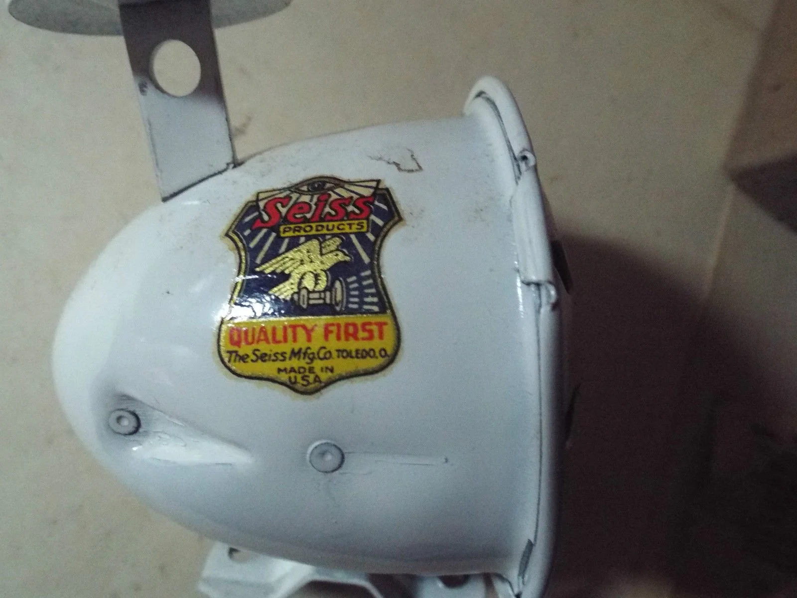 Close-up of a white Seiss brand electrical device with a yellow and red logo that reads "Seiss PRODUCTS," featuring a lion emblem and the text "QUALITY FIRST" and "Made in U.S.A."