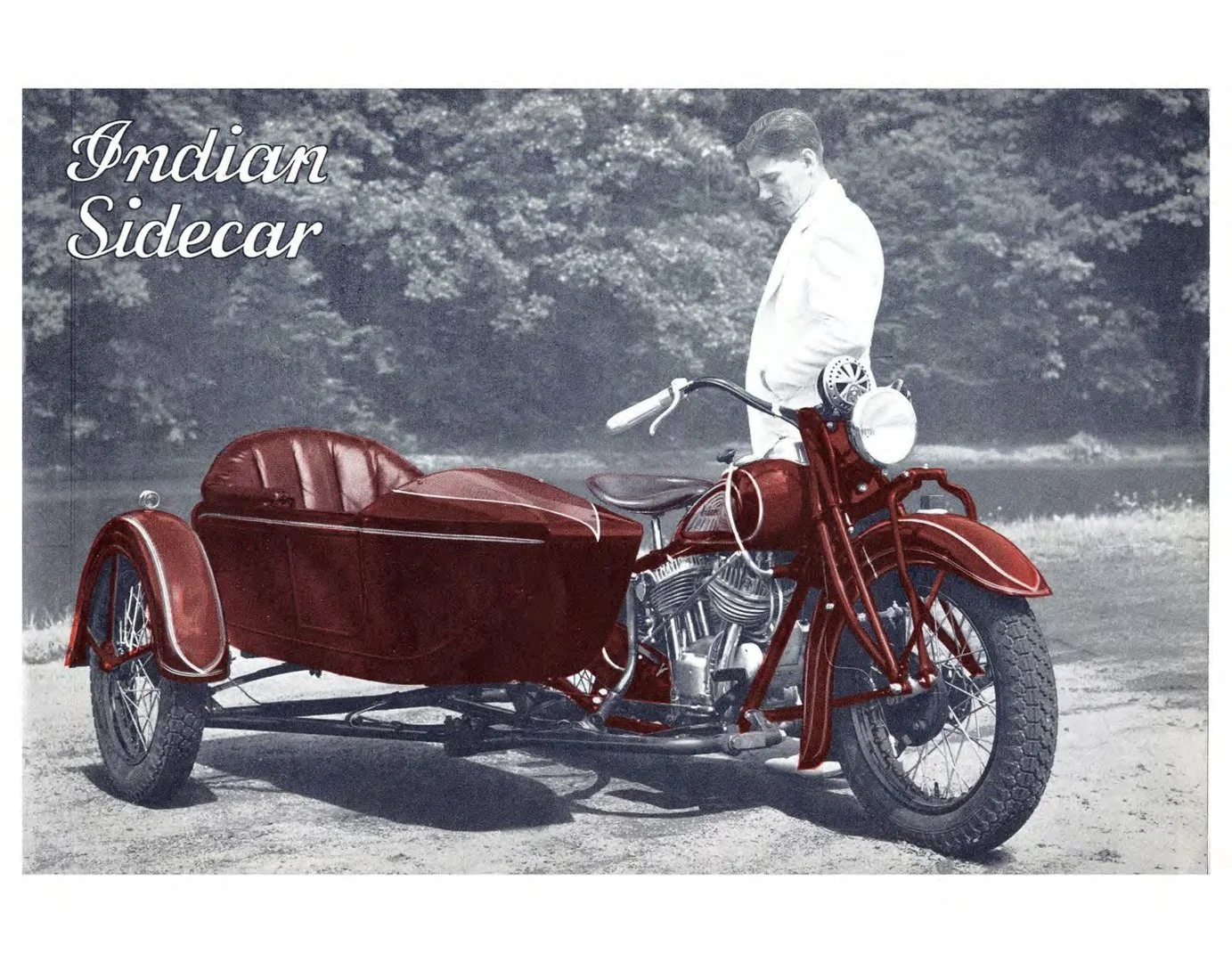 Black and white photograph of a vintage red Indian Sidecar motorcycle, with a man in a white suit standing behind it, outdoors with trees and grass in the background.