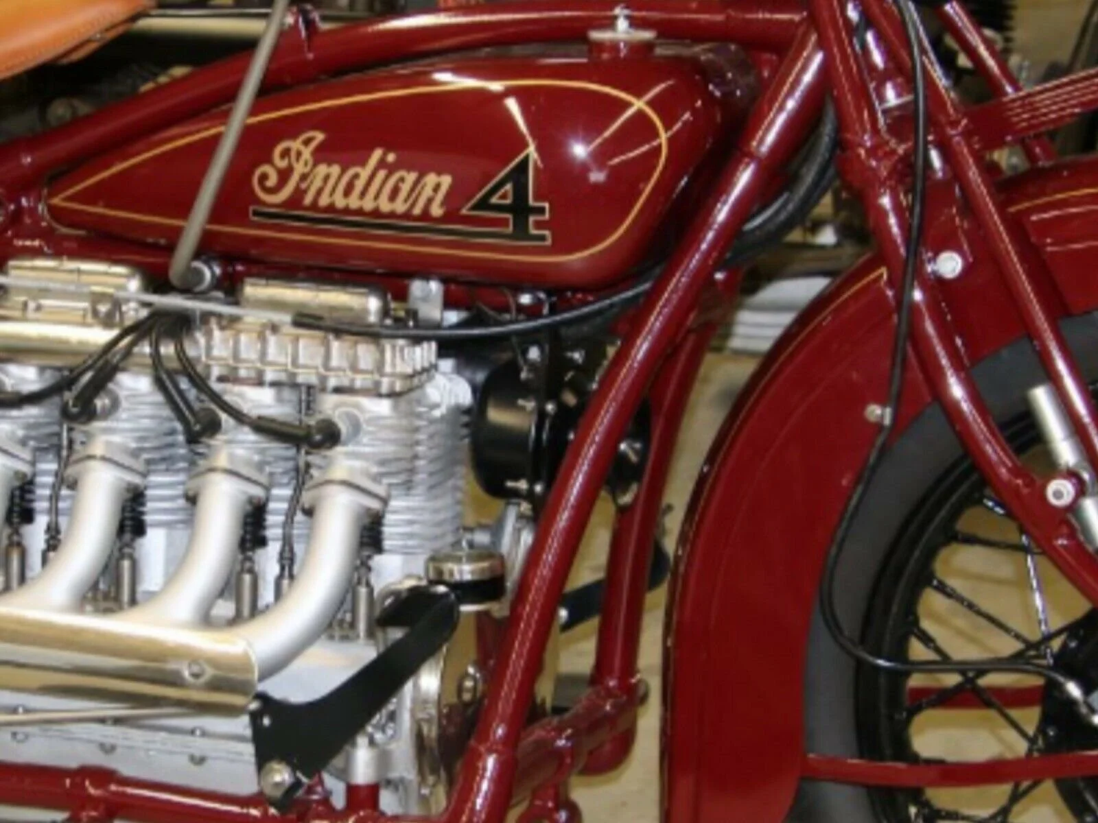 Close-up of a vintage red Indian 4 motorcycle showing the engine and branding.