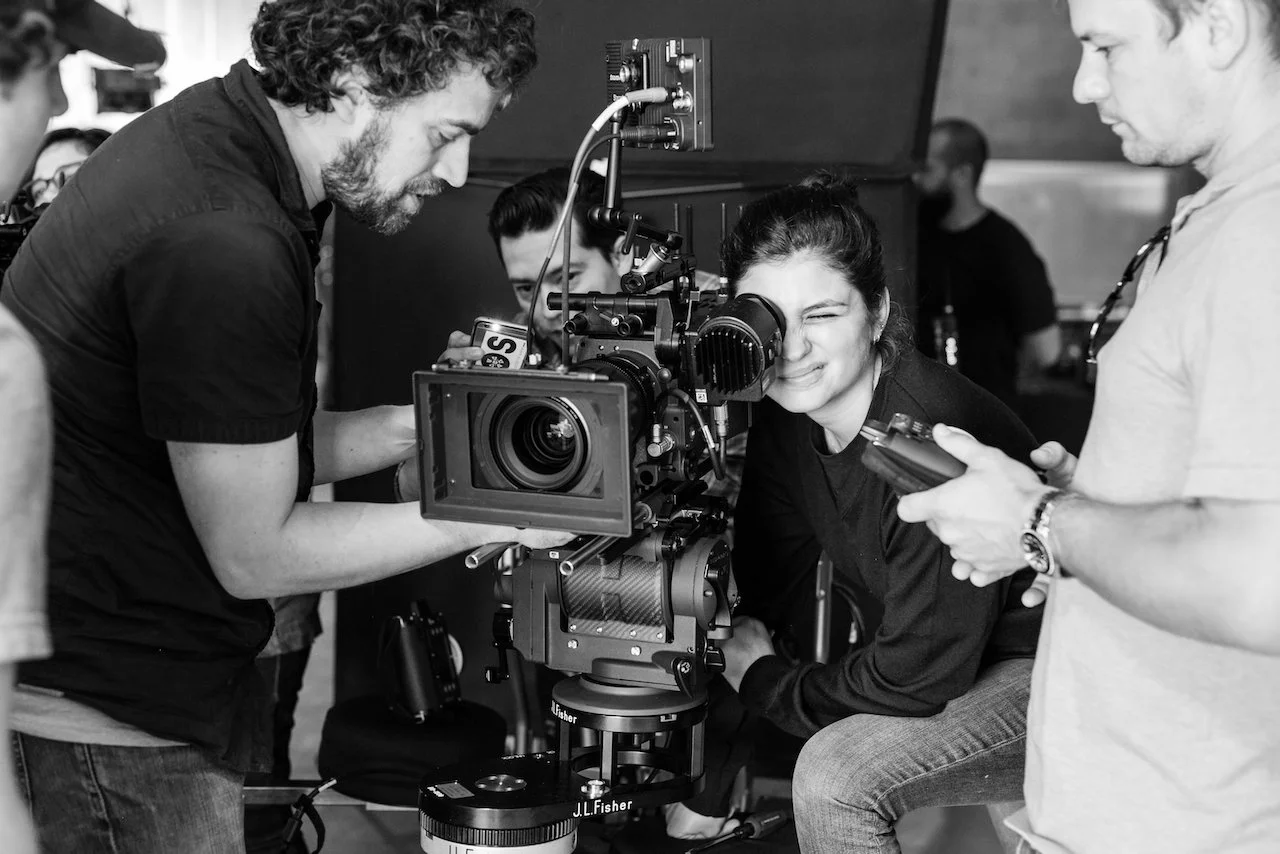 Filmmakers working with a professional camera on a film set.