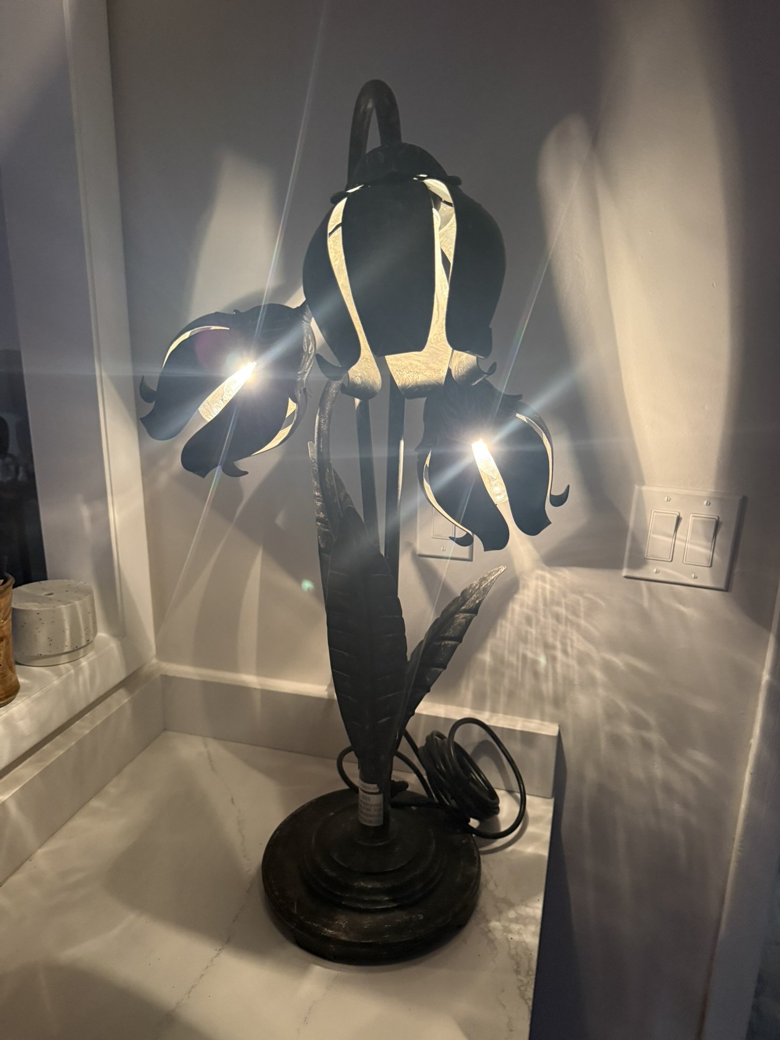 Vintage decorative lamp shaped like a flower with petals and leaves, made of metal with integrated light source.