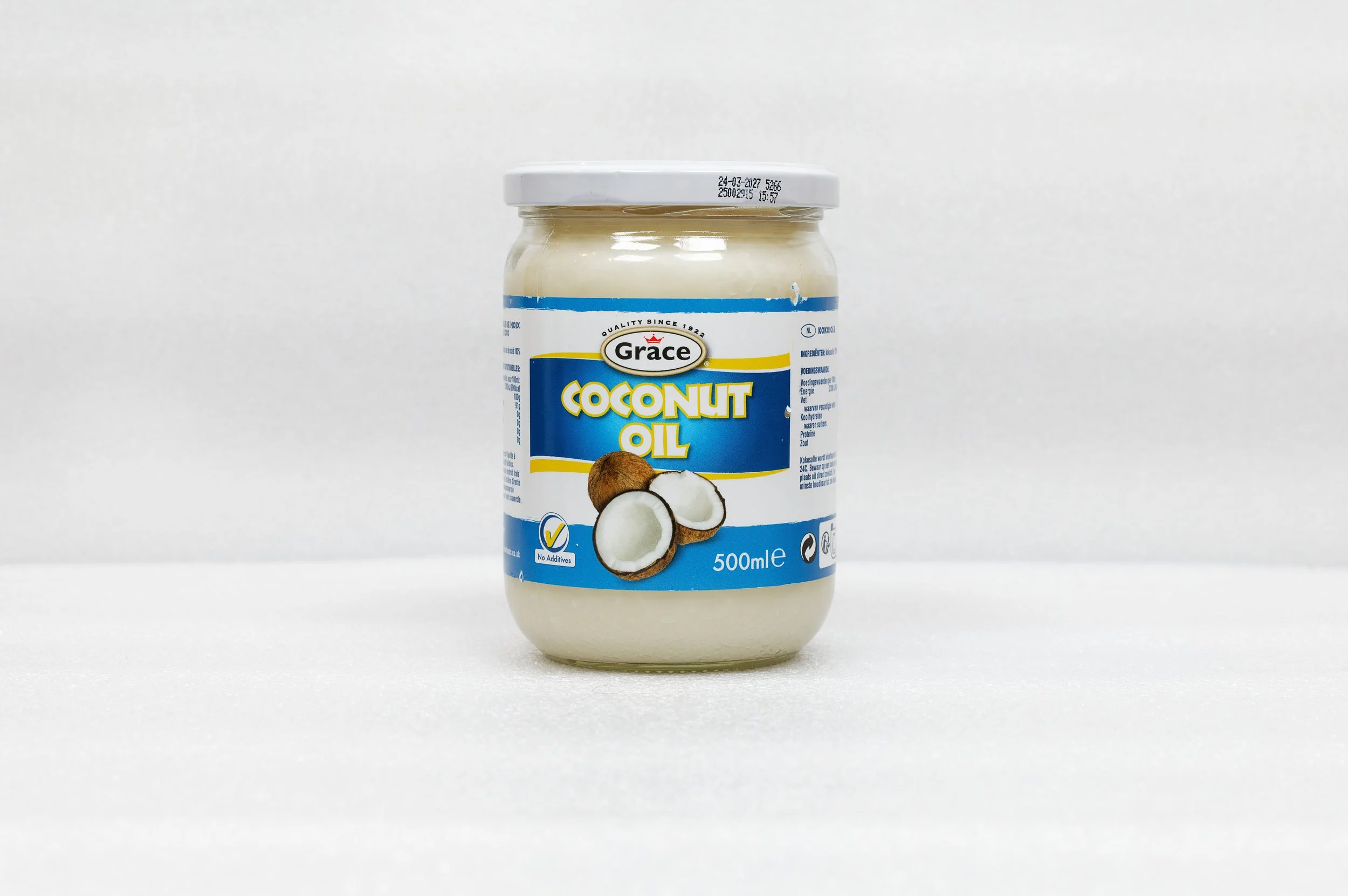 Bocal de huile de noix de coco Grace de 500 ml. Étiquette bleue avec des images de noix de coco entières et coupées, également marqué "No Additives".