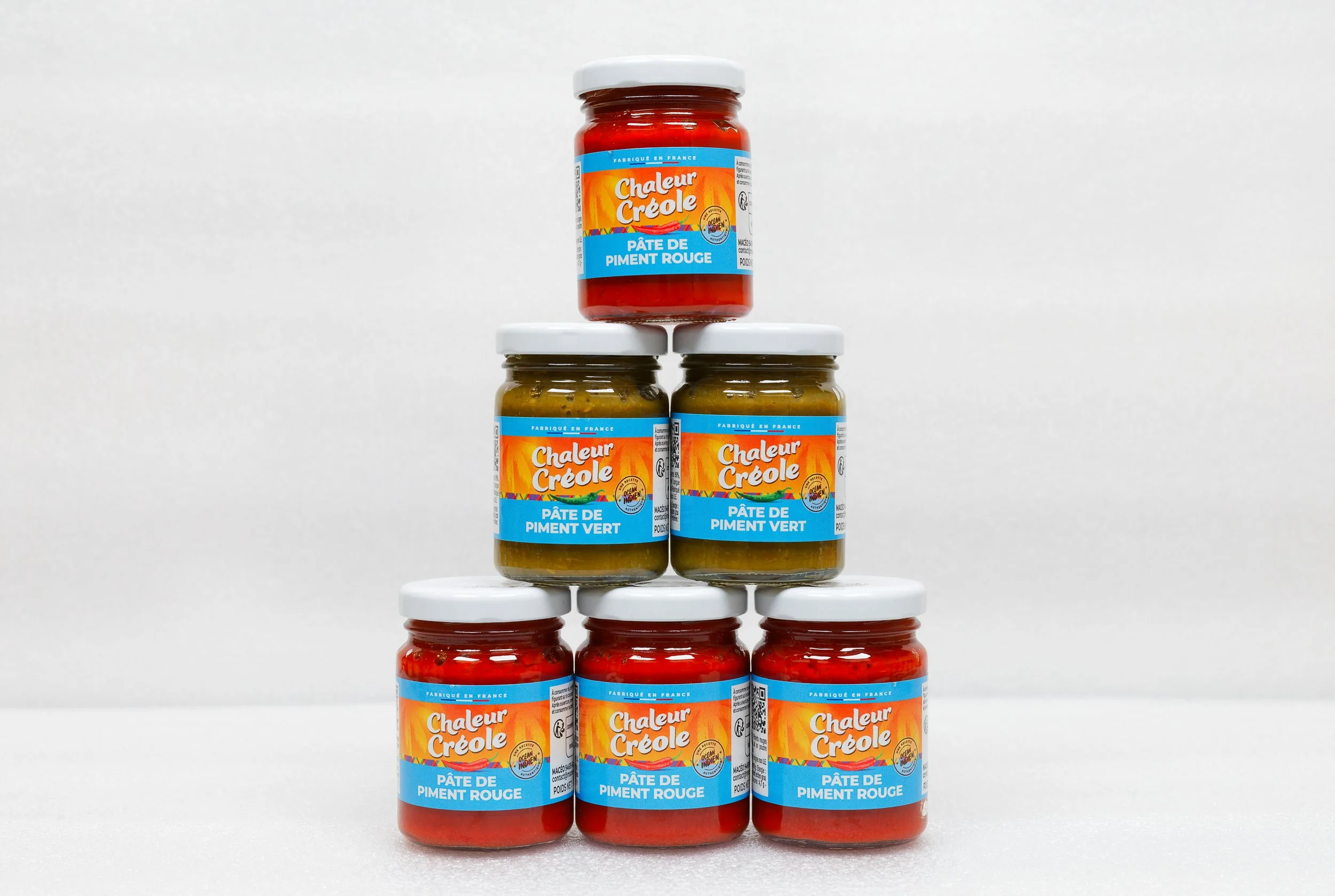 Pots de pâte de piment rouge et vert empilés en forme de pyramide