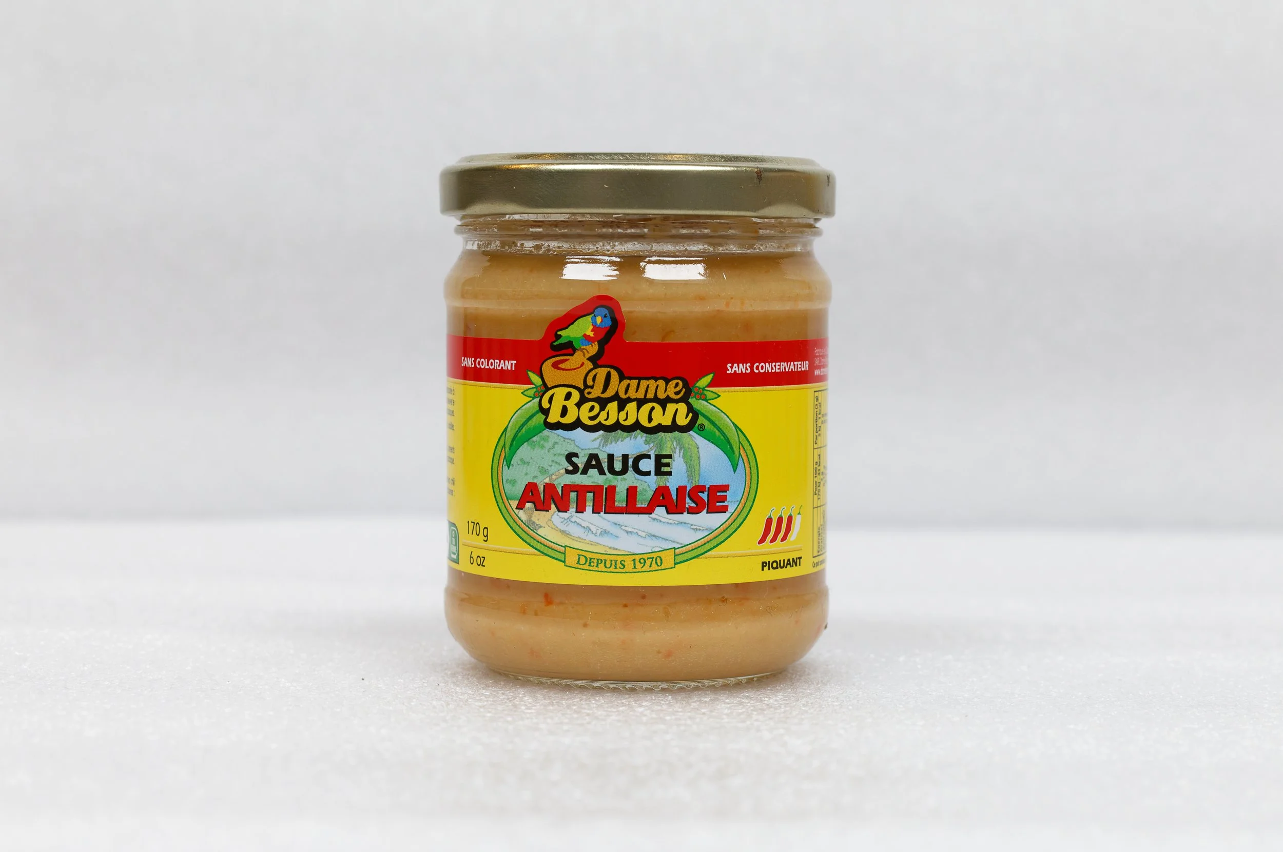 Bocal de sauce antillaise Dame Besson avec étiquette jaune et rouge.