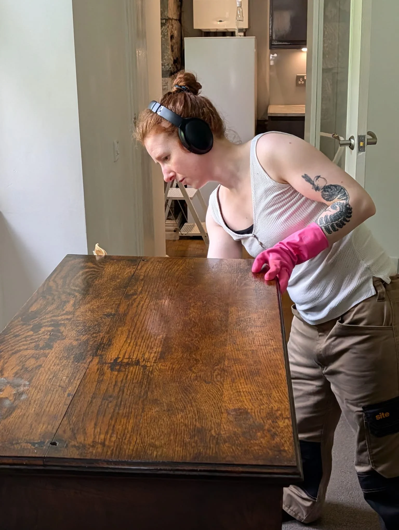 Woman cleaning a wooden dresser to high finish